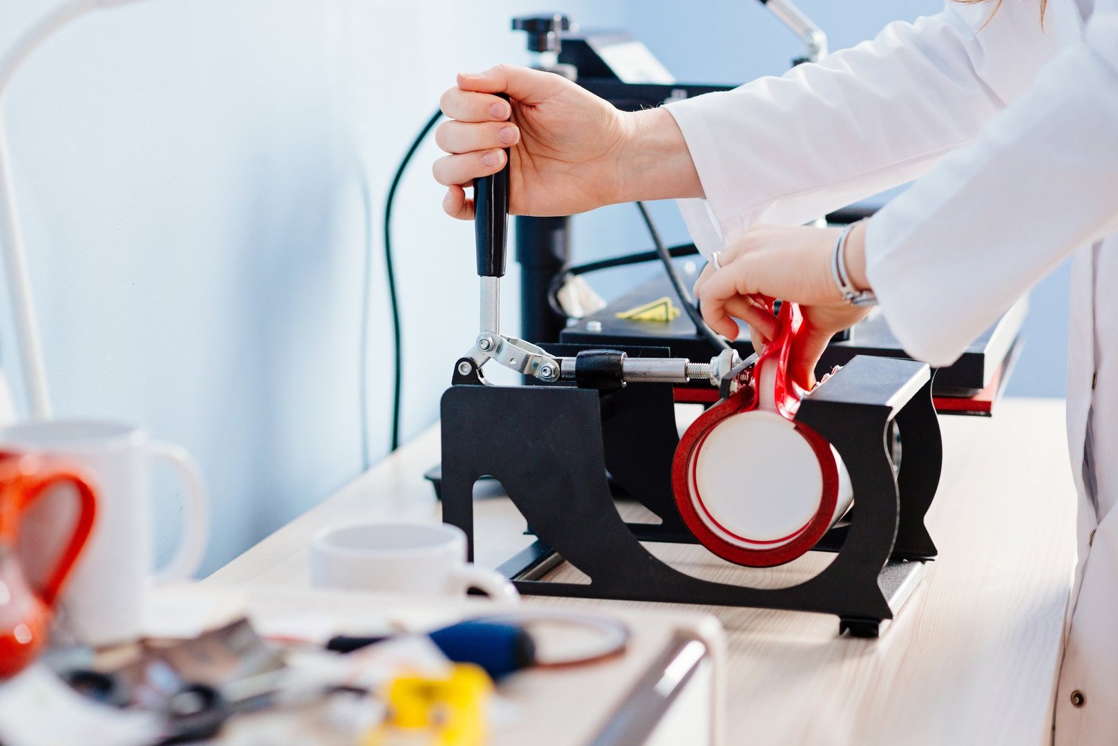 Woman making thermal transfer print on white mug