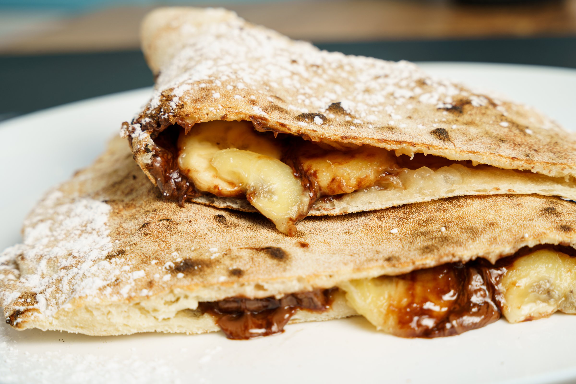 Italian dessert - calzone filled with chocolate, banana and powdered sugar