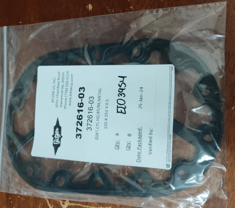 Motorcycle gasket set in packaging with part numbers and verification details on a label.