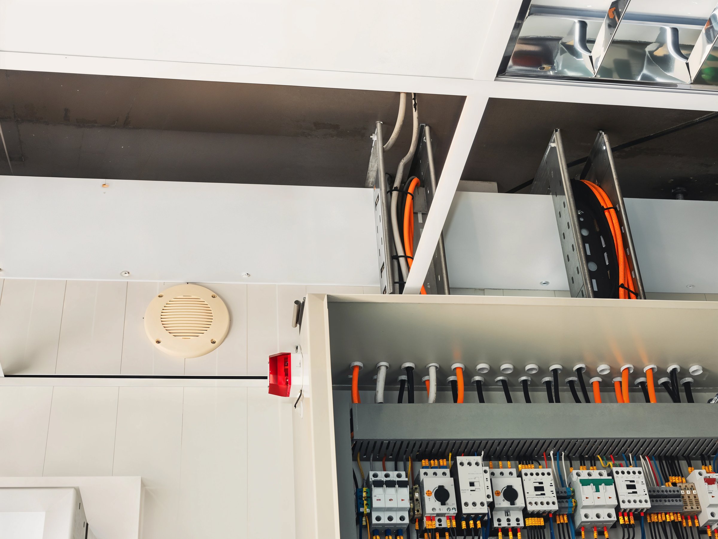 Close-up shot of an electrical panel filled with wiring and circuit breakers, showcasing the intricate details of the electrical infrastructure.