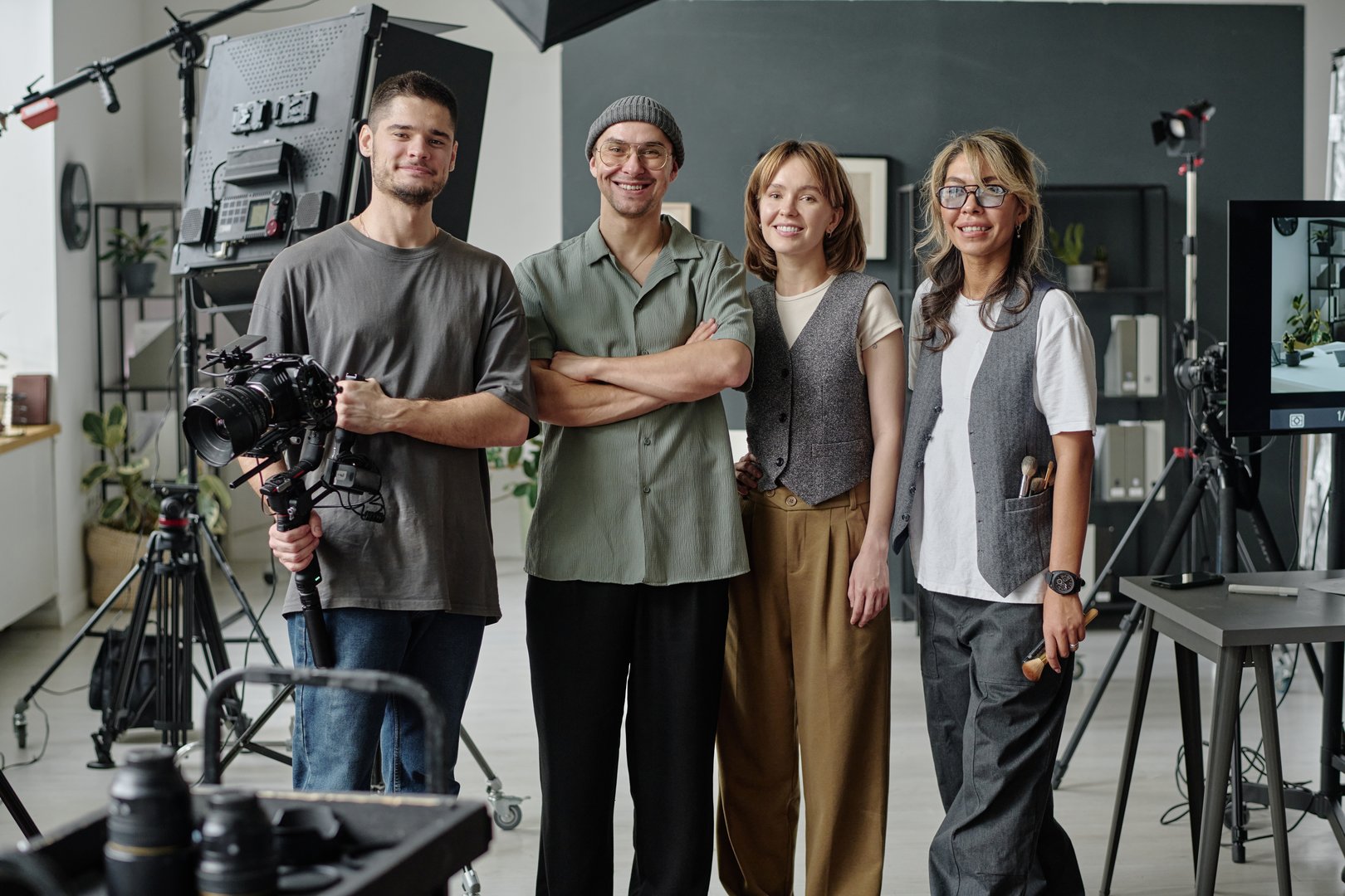 Portrait of smiling crew surrounded with equipment for filmmaking
