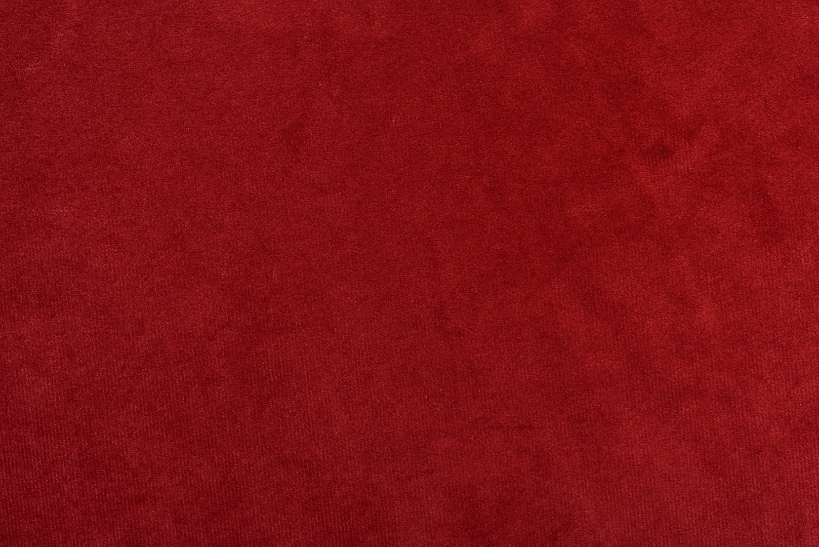 Red fabric background of soft and smooth textile material. Abstract red velvet fabric surface. Fabric texture for design and decoration. Top view.