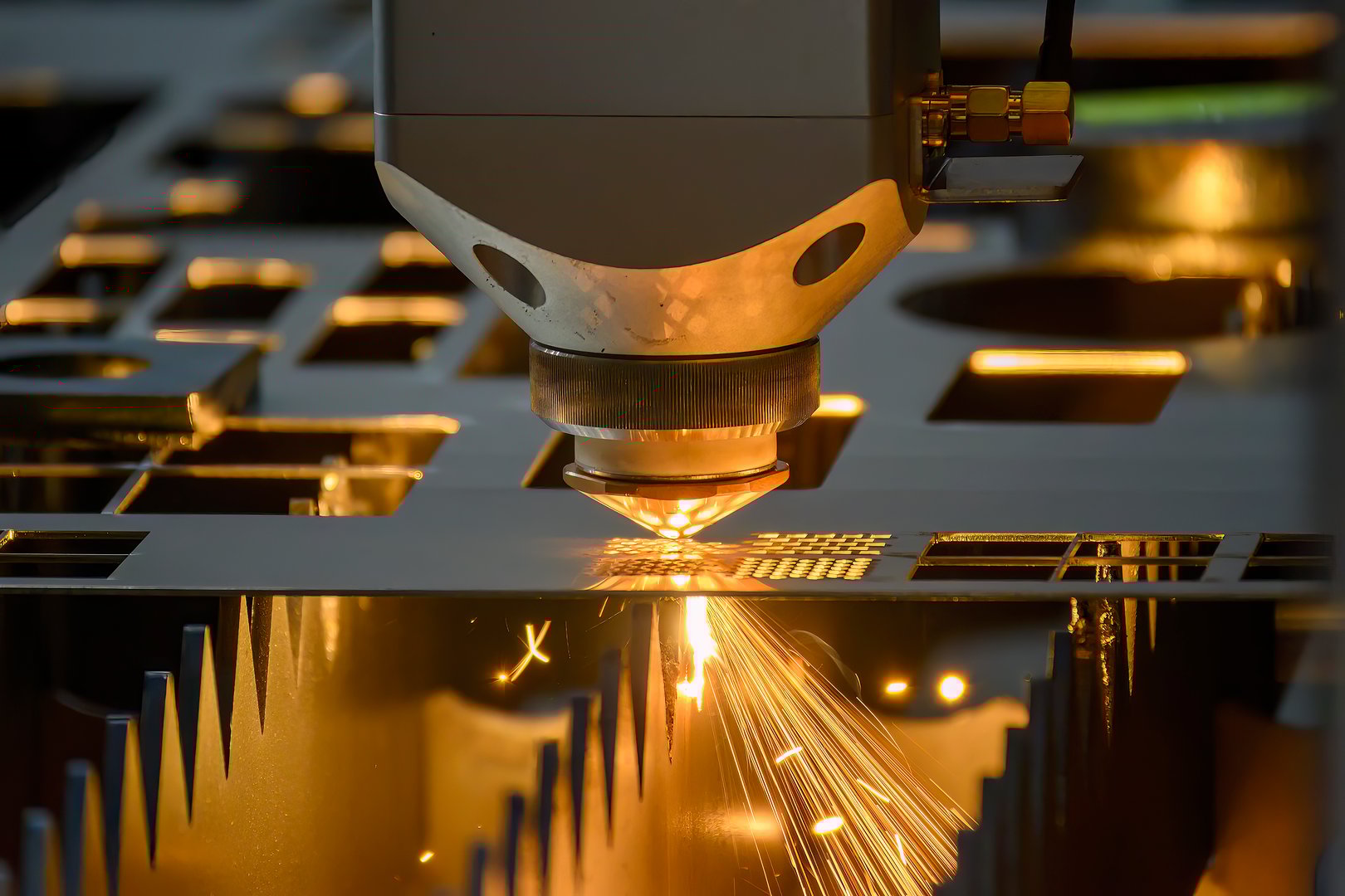 The fiber laser cutting machine  cut the metal plate with the sparkling light. The hi-technology sheet metal manufacturing process by laser cutting machine.