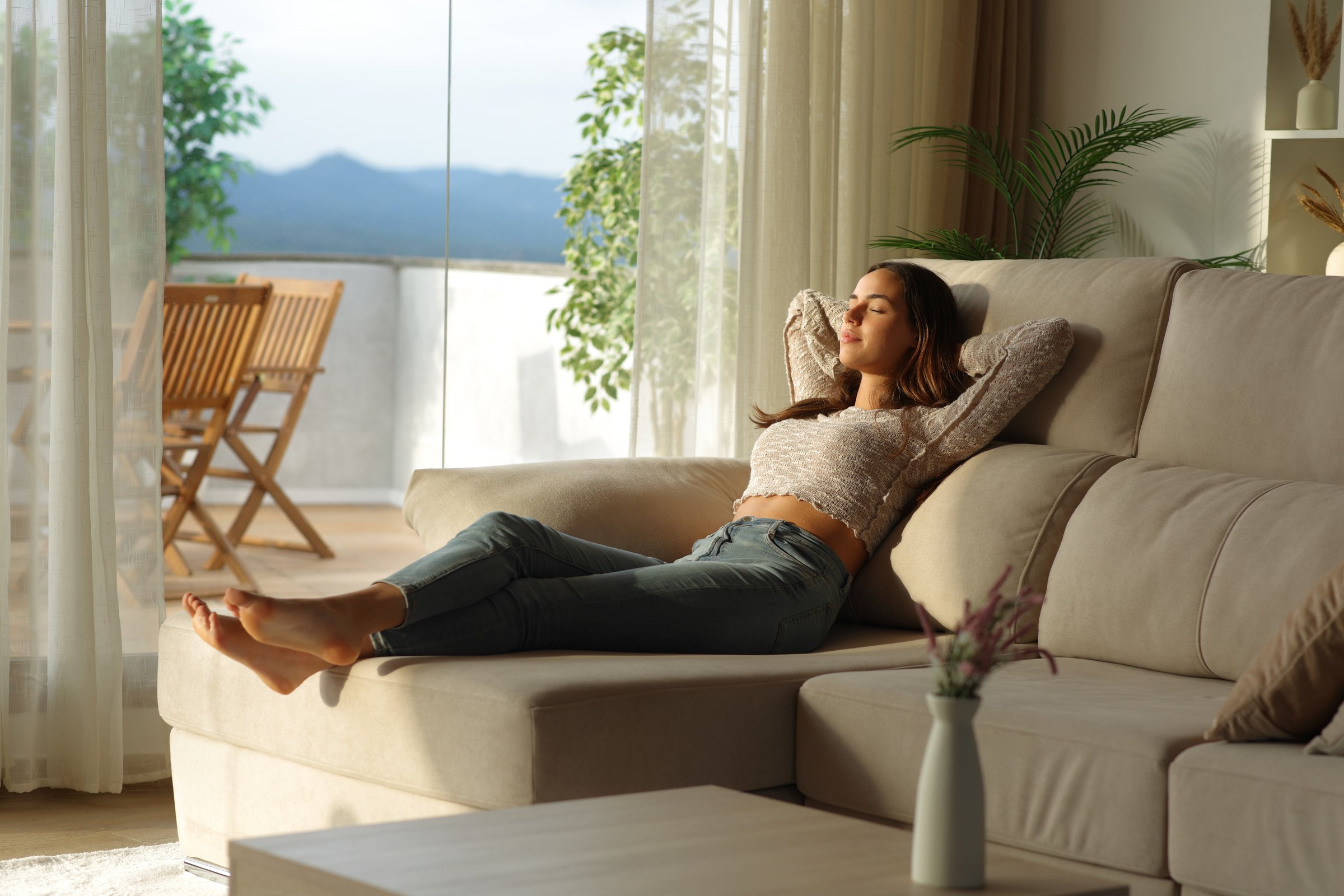 Woman relaxing at home sitting on sofa