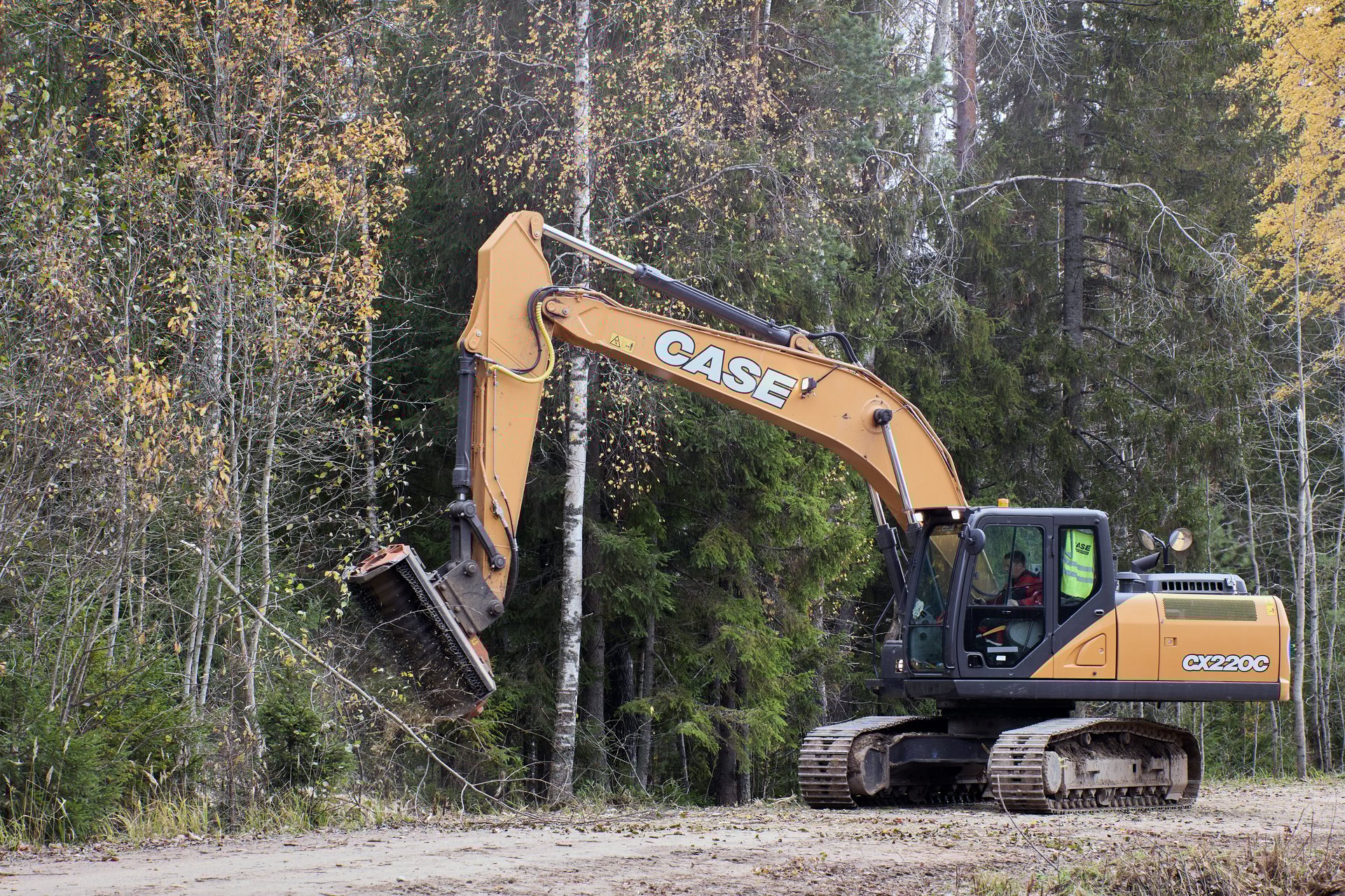 Lemozero, Olonets, Karelia, Russia - October 10, 2022: Forestry mulching attachment head attached to boom of an excavator clearing road side.