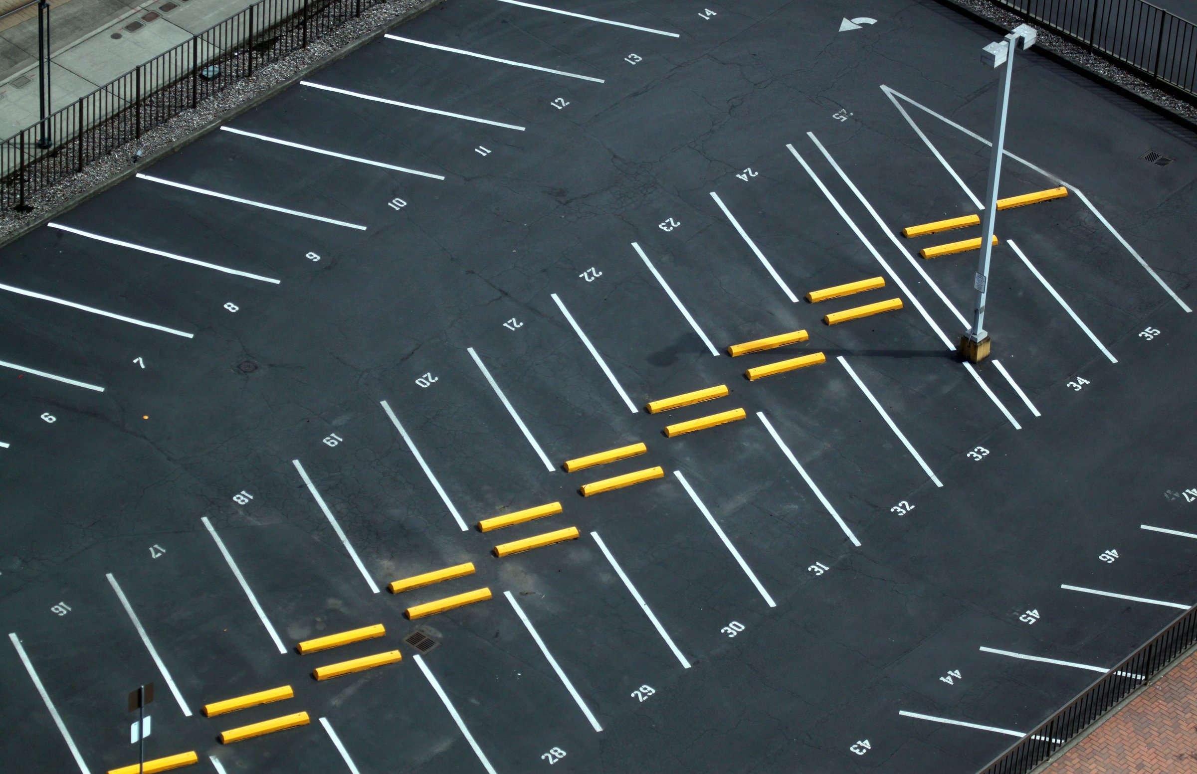 Abstract shots of parking lot with white and yellow stripes, arrows, crosswalks, signs, and symbols.
