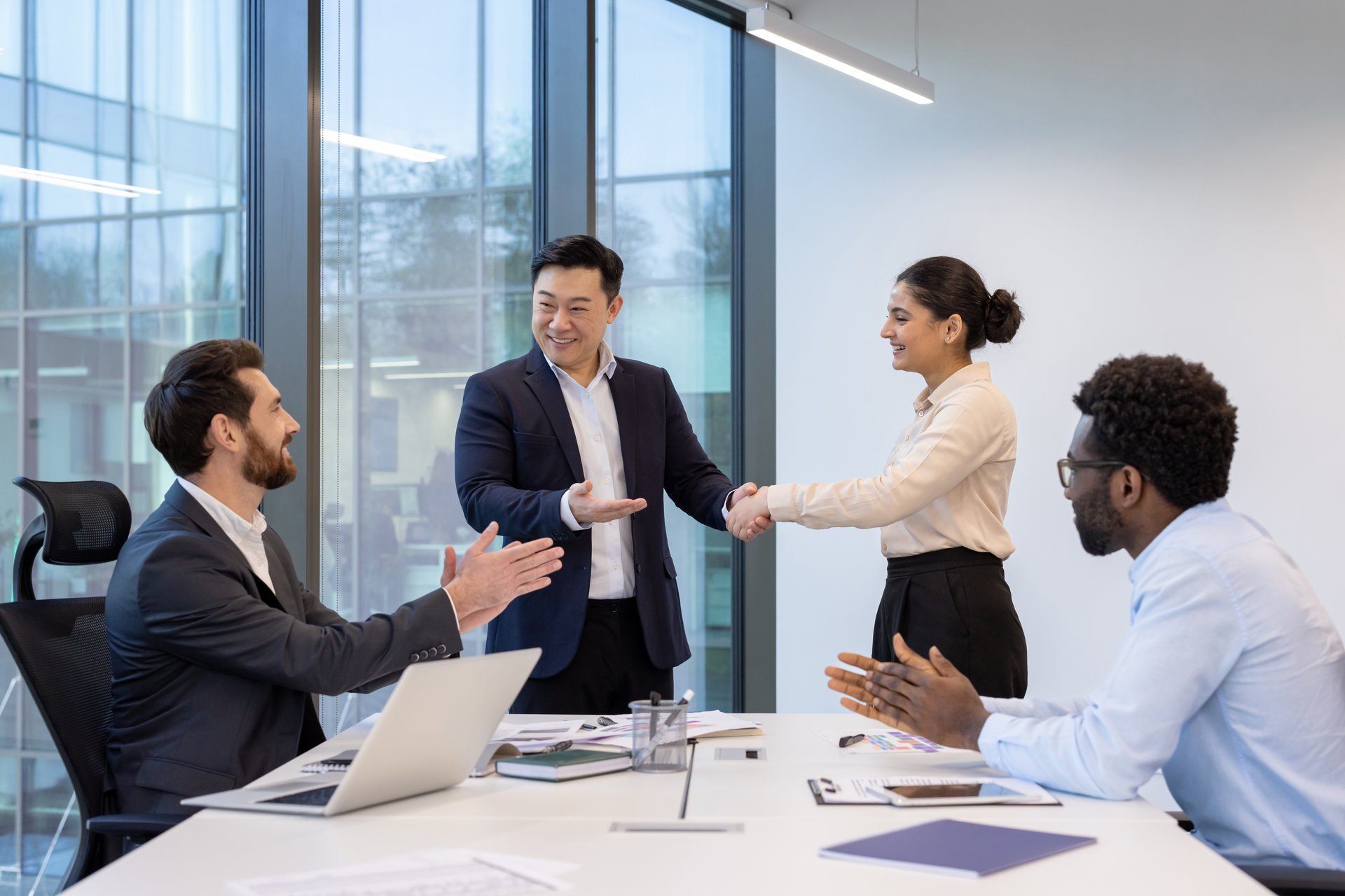 비즈니스 미팅에서 손을 잡으며 새로운 파트너십을 축하하는 동료들