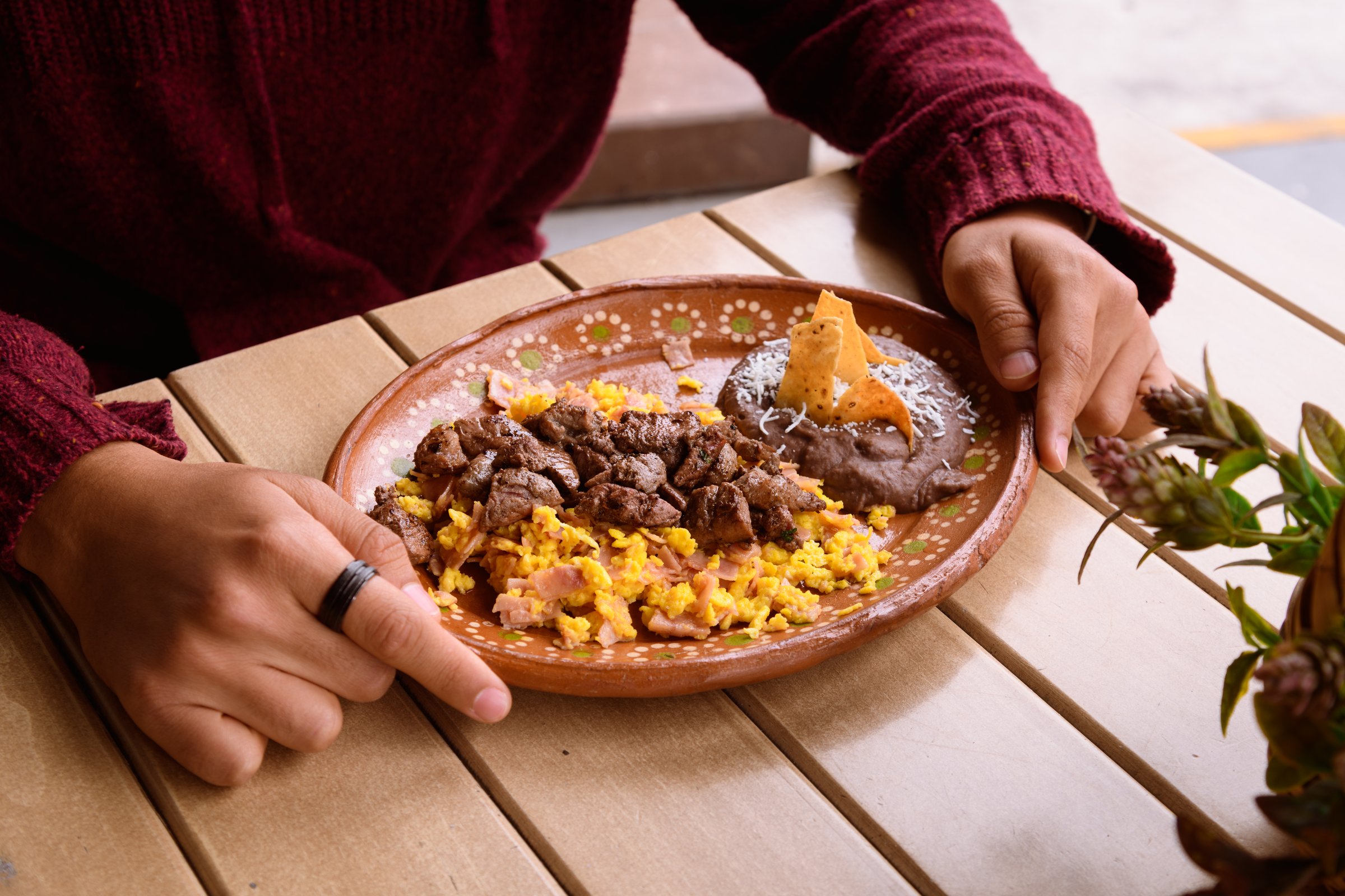 Unrecognizable Hispanic latin brunette man next to scrambled eggs with steak