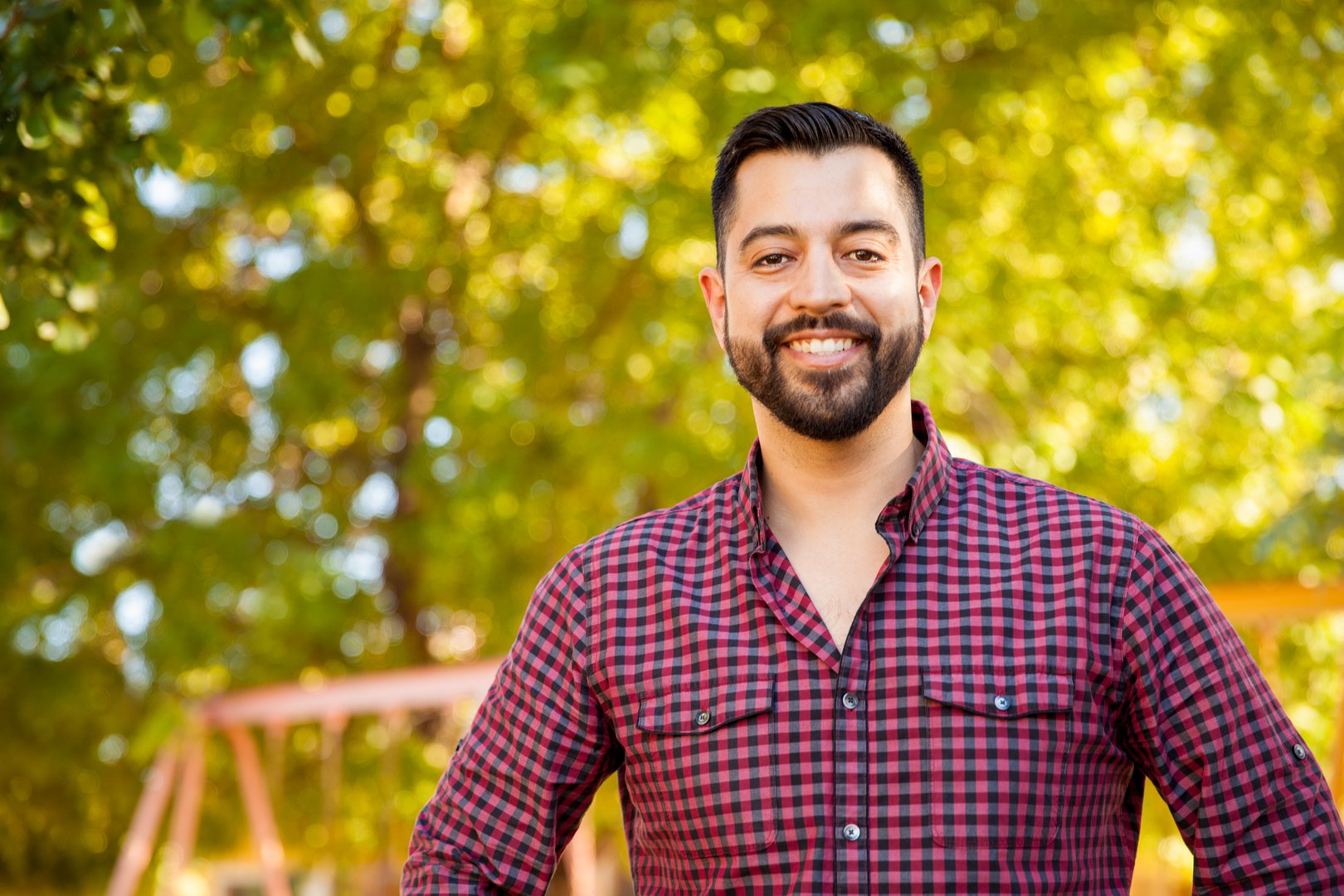Portrait of a handsome Latin young man with a beard hanging out outdoors