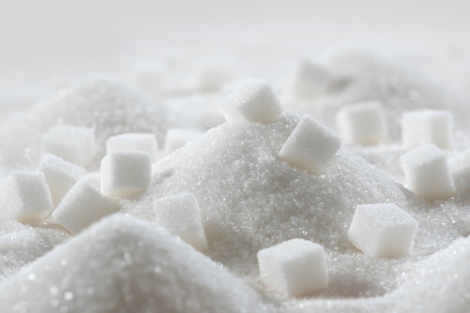 White granulated sugar and refined sugar cubes close-up