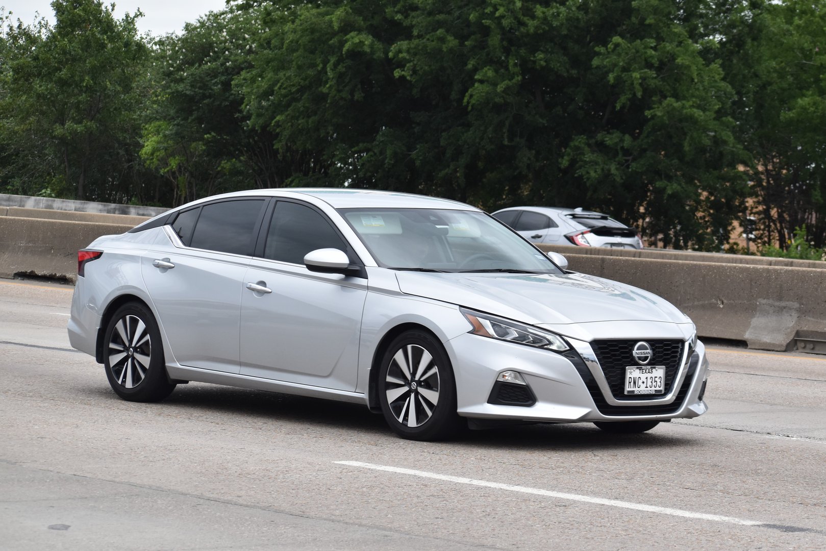 Houston, TX USA - 5/11/2024 - A portrait of a Nissan Altima traveling down a highway in moderate traffic