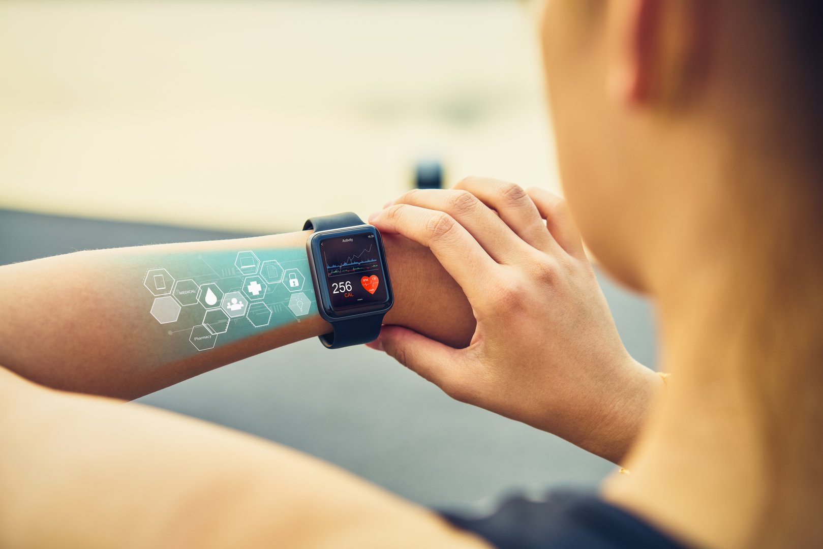 Young woman checking the sports watch with screen healthcare icon,  measuring heart rate and performance after running.