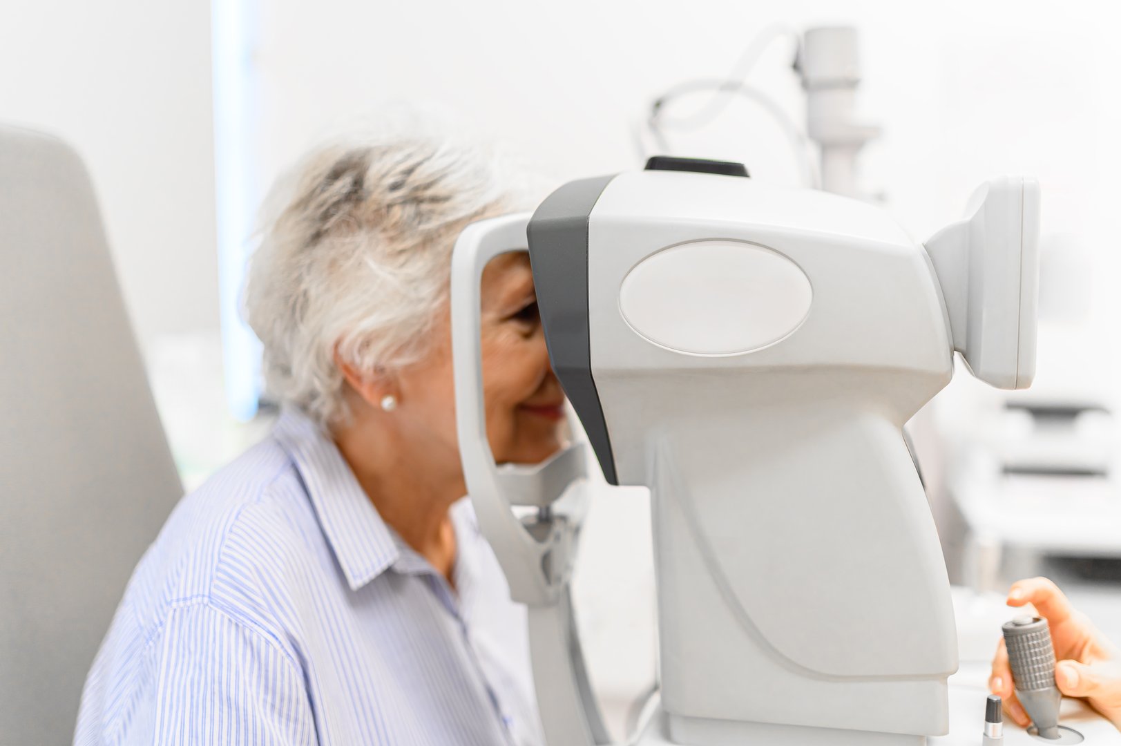 Senior woman undergoing eye examination with slit lamp for clear vision checkup conducted at clinic