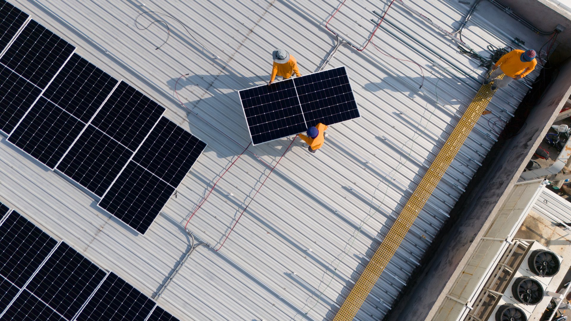 Aerial top view of a technician drone installing solar panels on the roof.