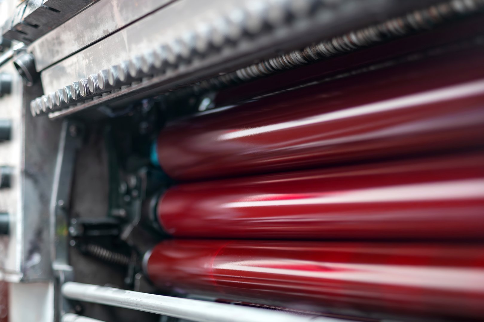 Magenta color and glossy rollers of offset printing machine. Offset ink colour. Selective focus.