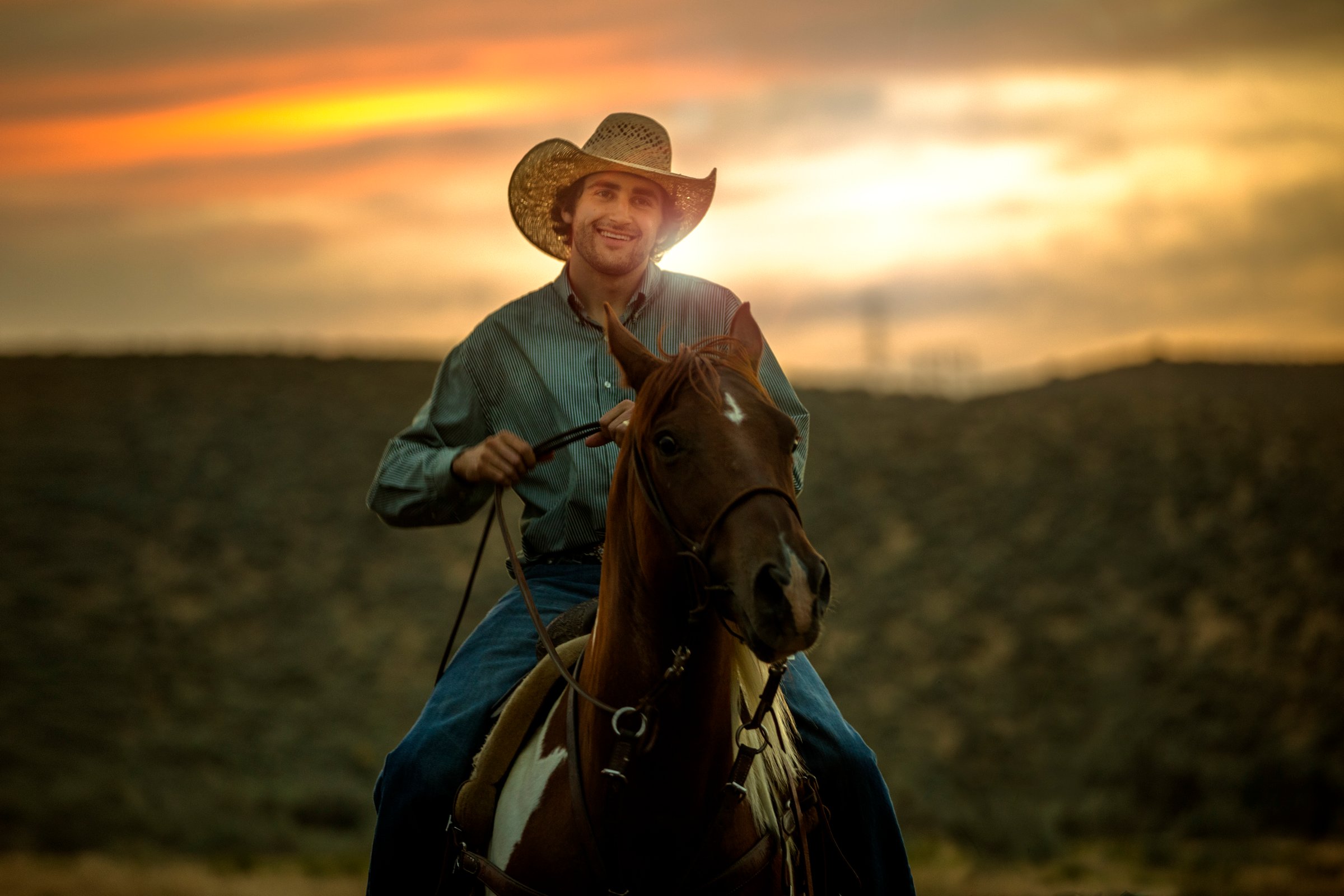 Cowboy riding at sunset