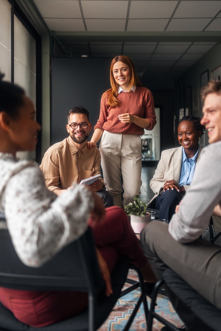 A friendly group of coworkers shares ideas and engages in a relaxed office setting atmosphere.