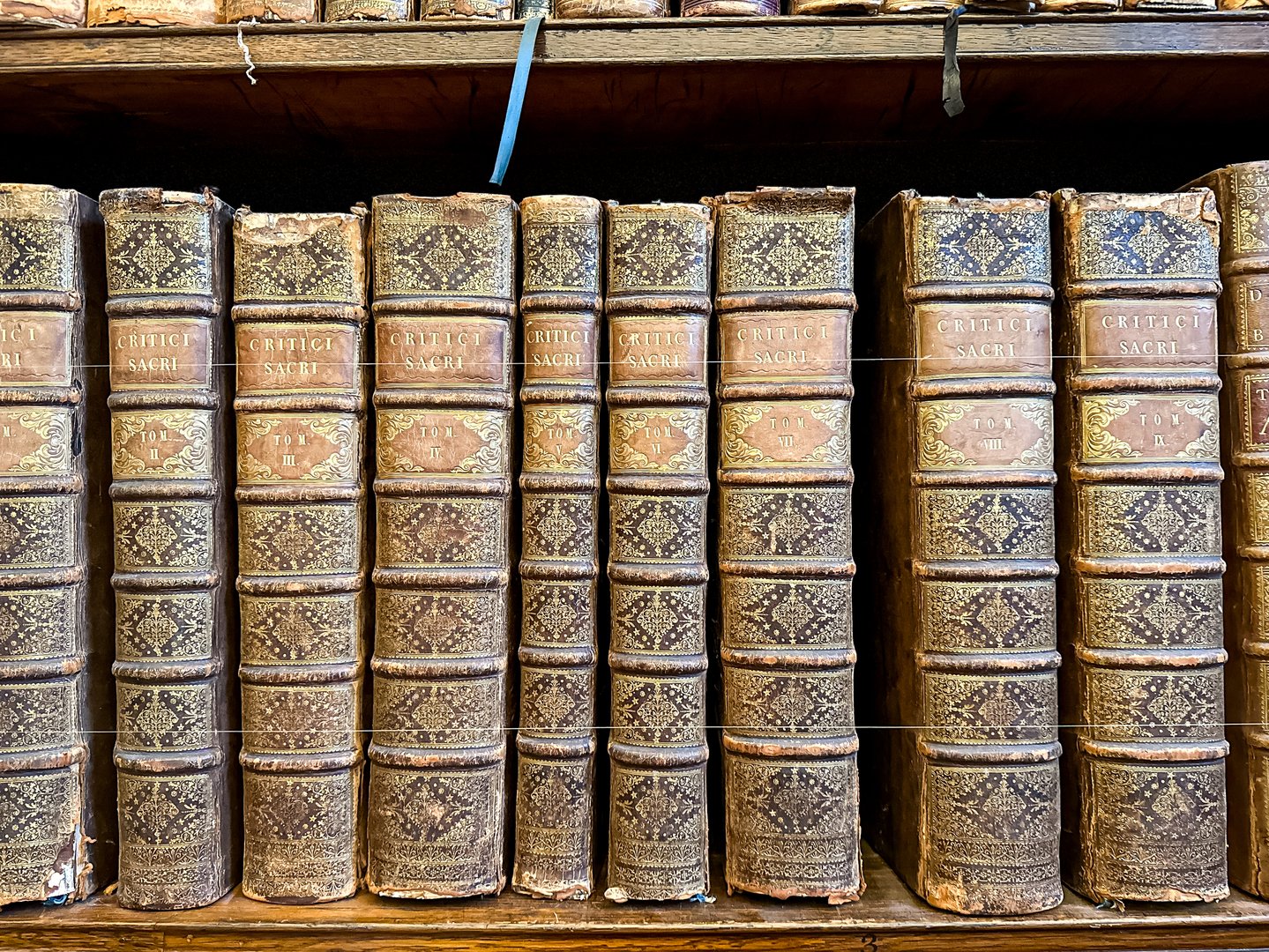 Antique Books on a wooden shelf. Old vintage books on wooden shelf. Tiled Bookshelf background. Concept on the theme of history, nostalgia, old age. Retro style. leather covered books.