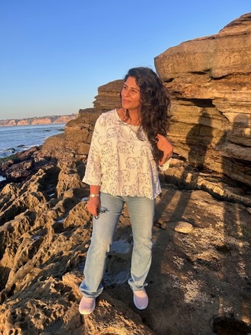 Sonal on a rock by the ocean, representing your grounded yet adventurous spirit