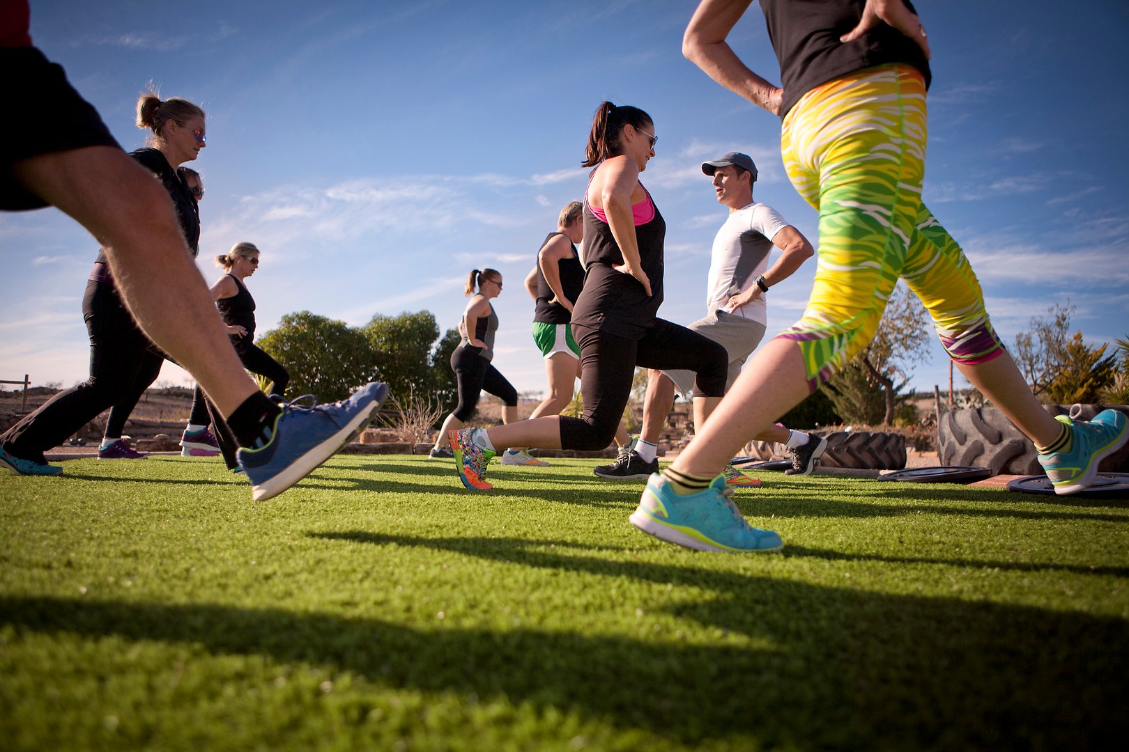 A group of people exercising and stretching in the Spanish sunshine with personal trainer.