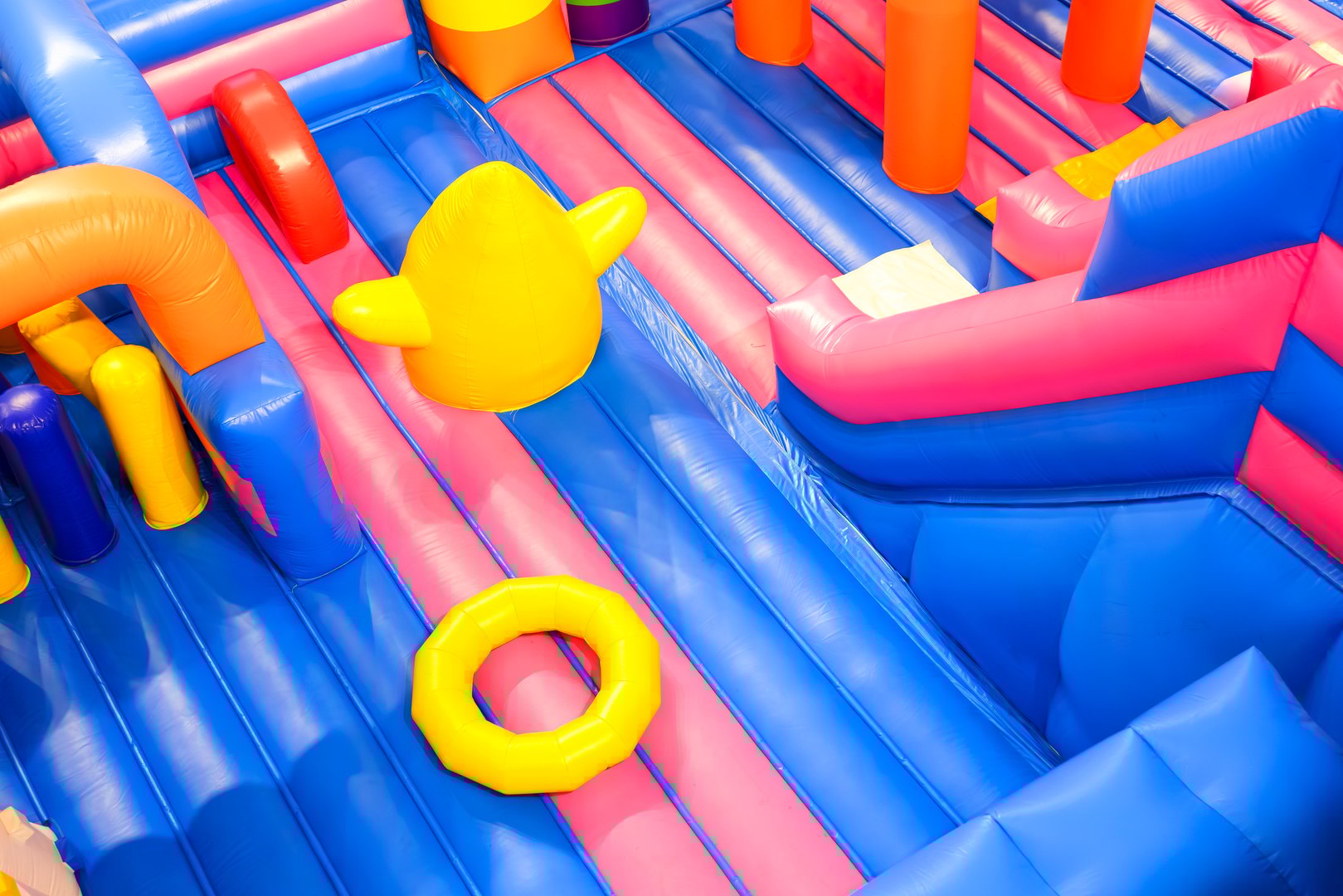 Inflatable jumping castle with colorful playground equipment and slide inside of department store, high angle and diagonal view