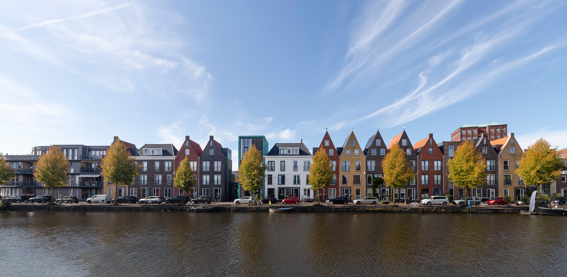 Nieuwe moderne kleurrijke huizen met verschillende gevels langs het water in de wijk Vathorst in Amersfoort in Nederland.