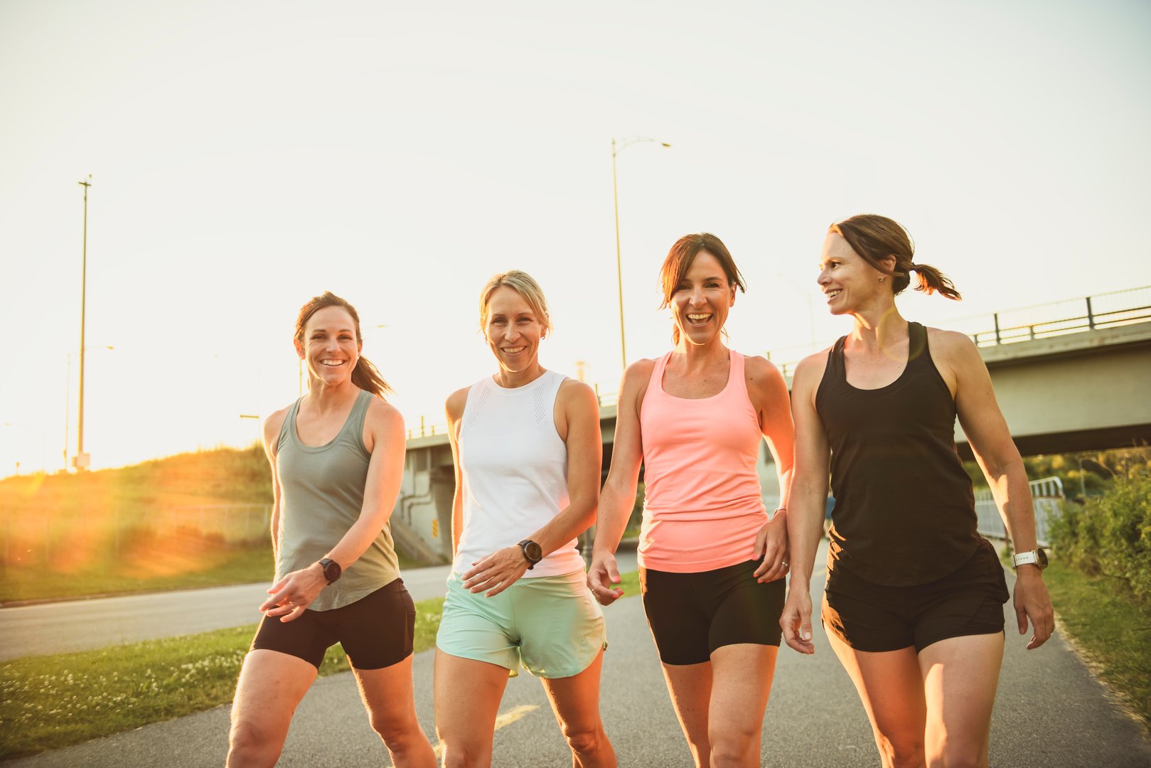 The females in sportswear walking together bright sunny park in summer