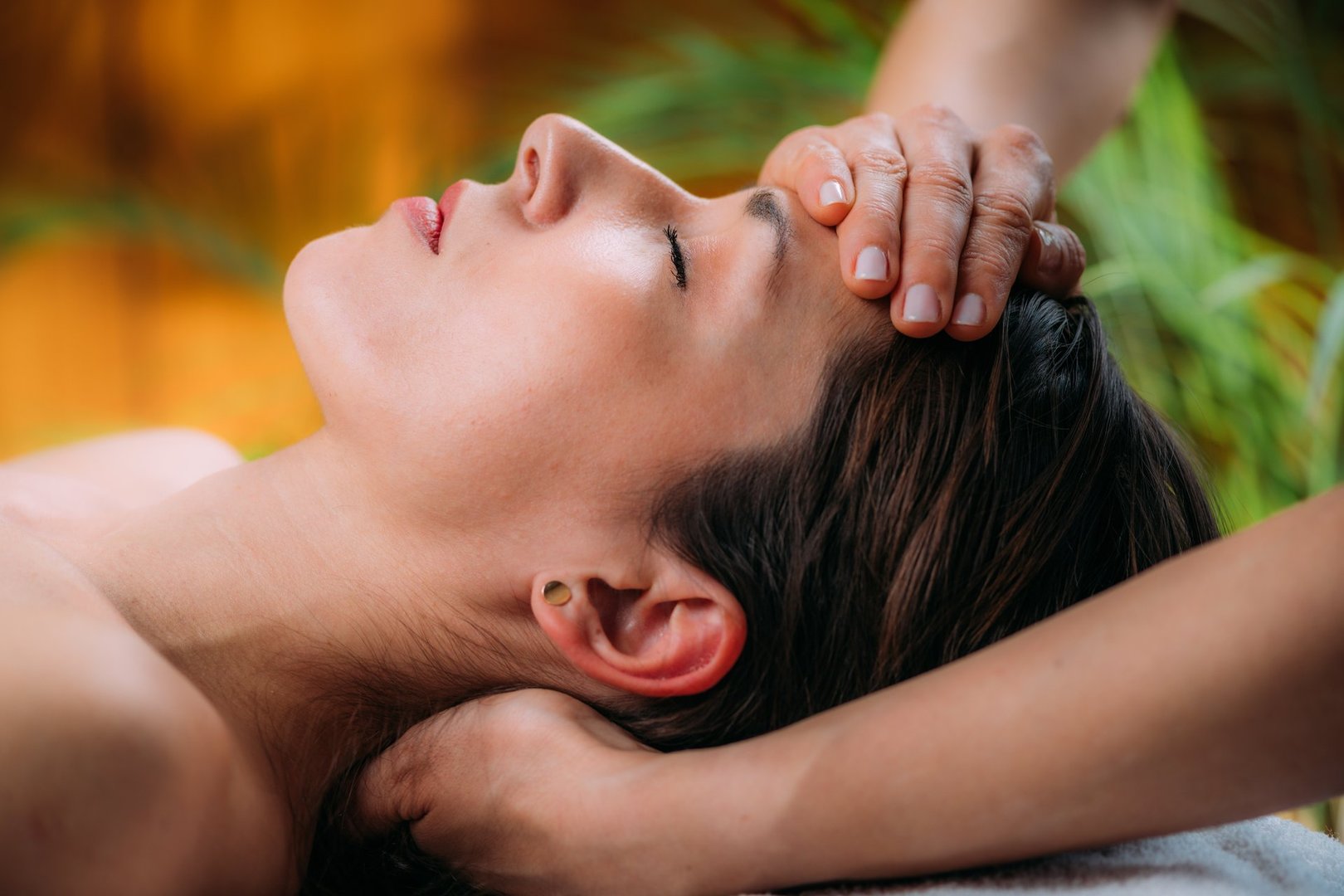 Craniosacral therapy massage. Therapist massaging woman's forehead.