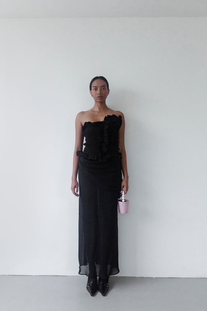 Gorgeous young woman wearing designer Black maxi dress looking stunning Beautiful Black Asian mixed ethnicity Fashion model studio portrait on white background Unique natural beauty Lookbook shoot evening wear Luxury style shopping