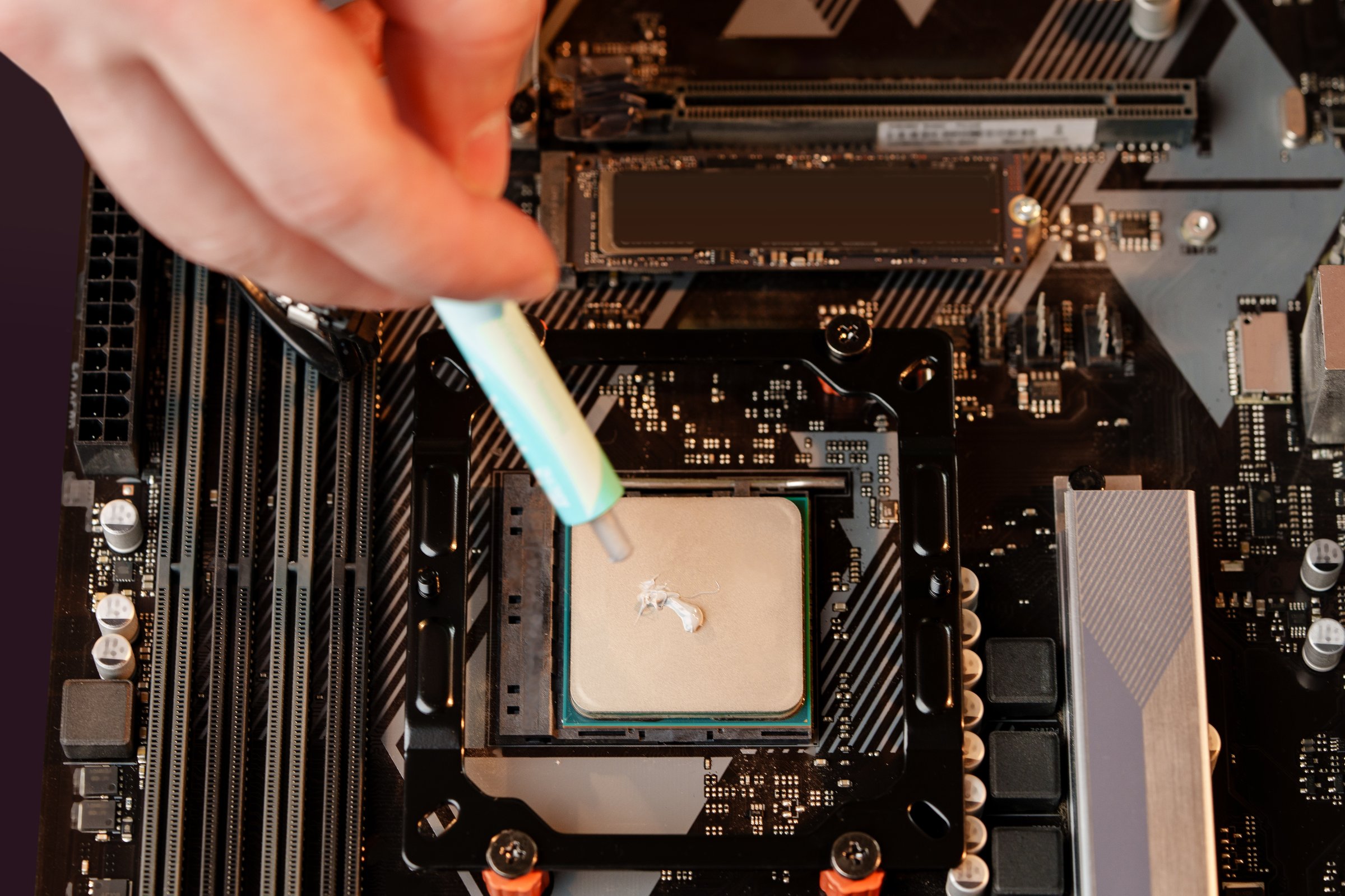 Man applies thermal paste to the CPU close up