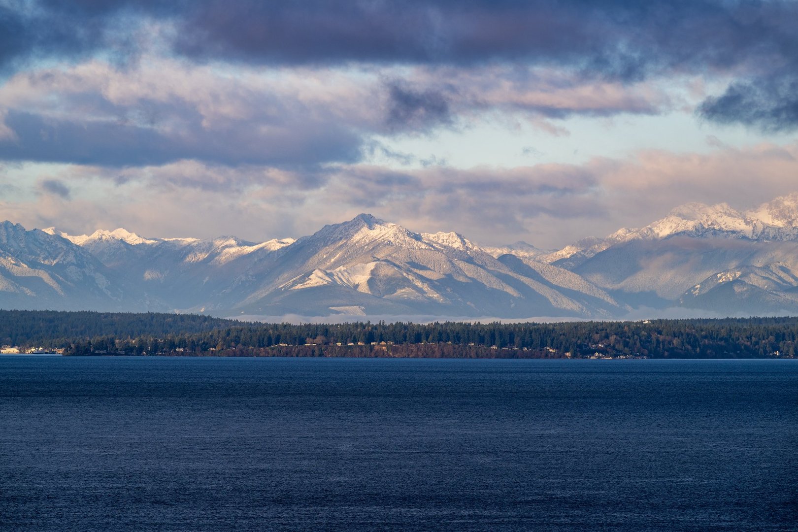 The Olympic Mountain Peaks in Washington State on a windy and cloudy winter day.