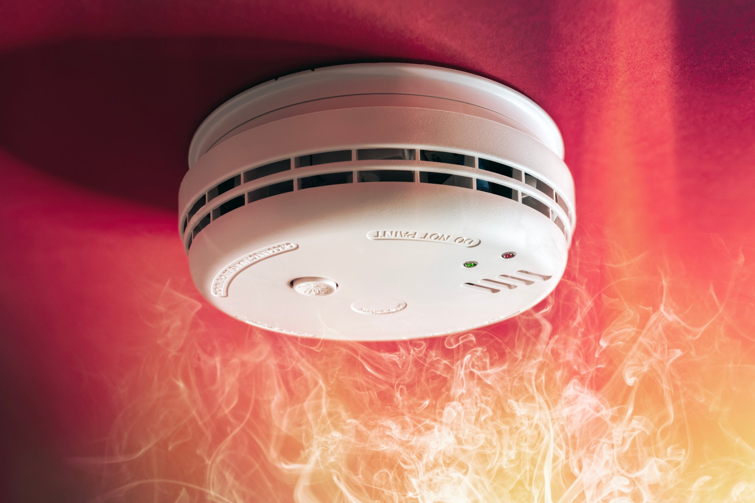 Smoke alarm detector and interlinked fire alarm in action background with copy space