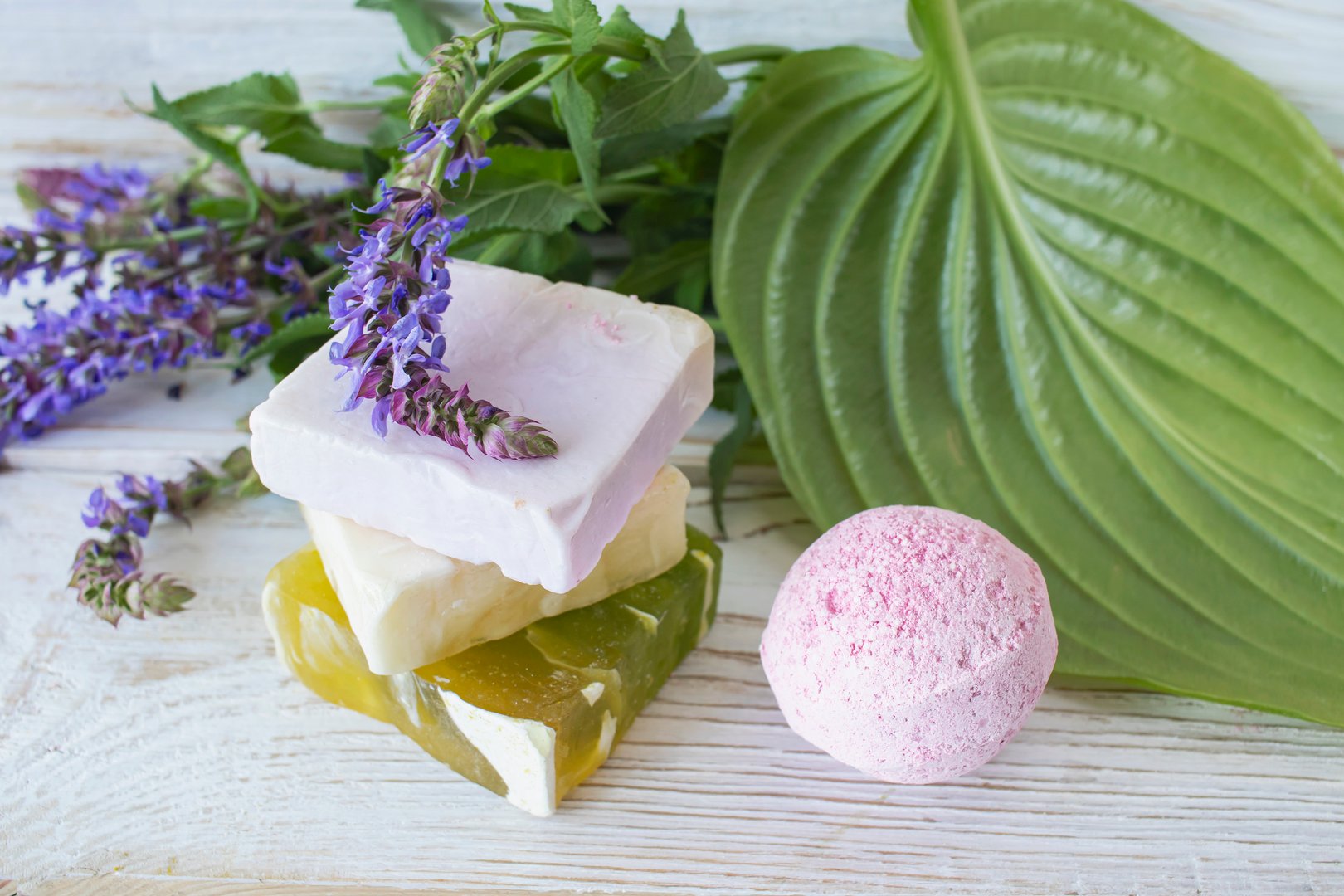 Spa still life with natural soap and fresh sage plant on wooden background.