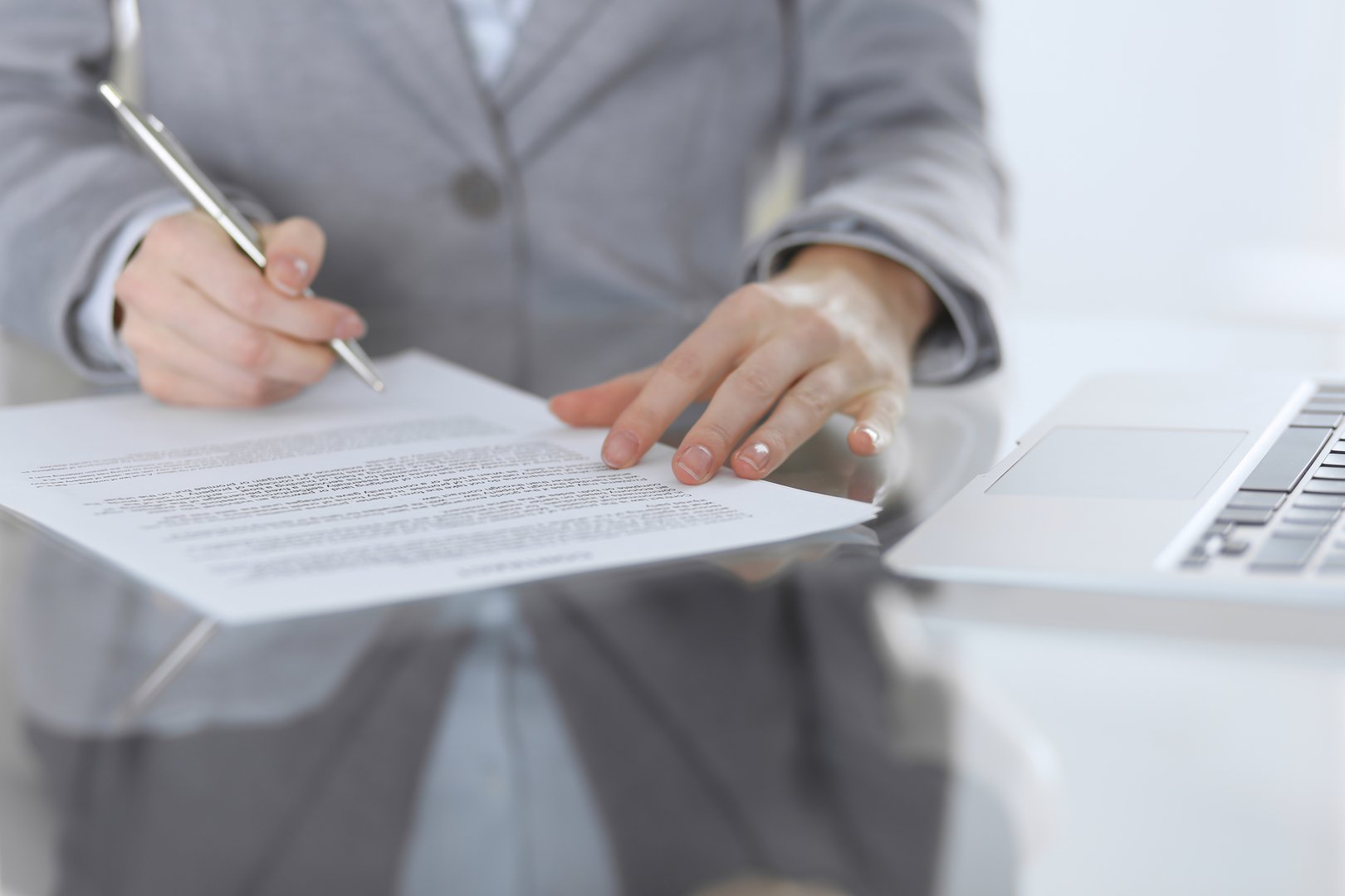 Close-up of female hands with pen over document,  business concept. Lawyer or business woman at work in office.