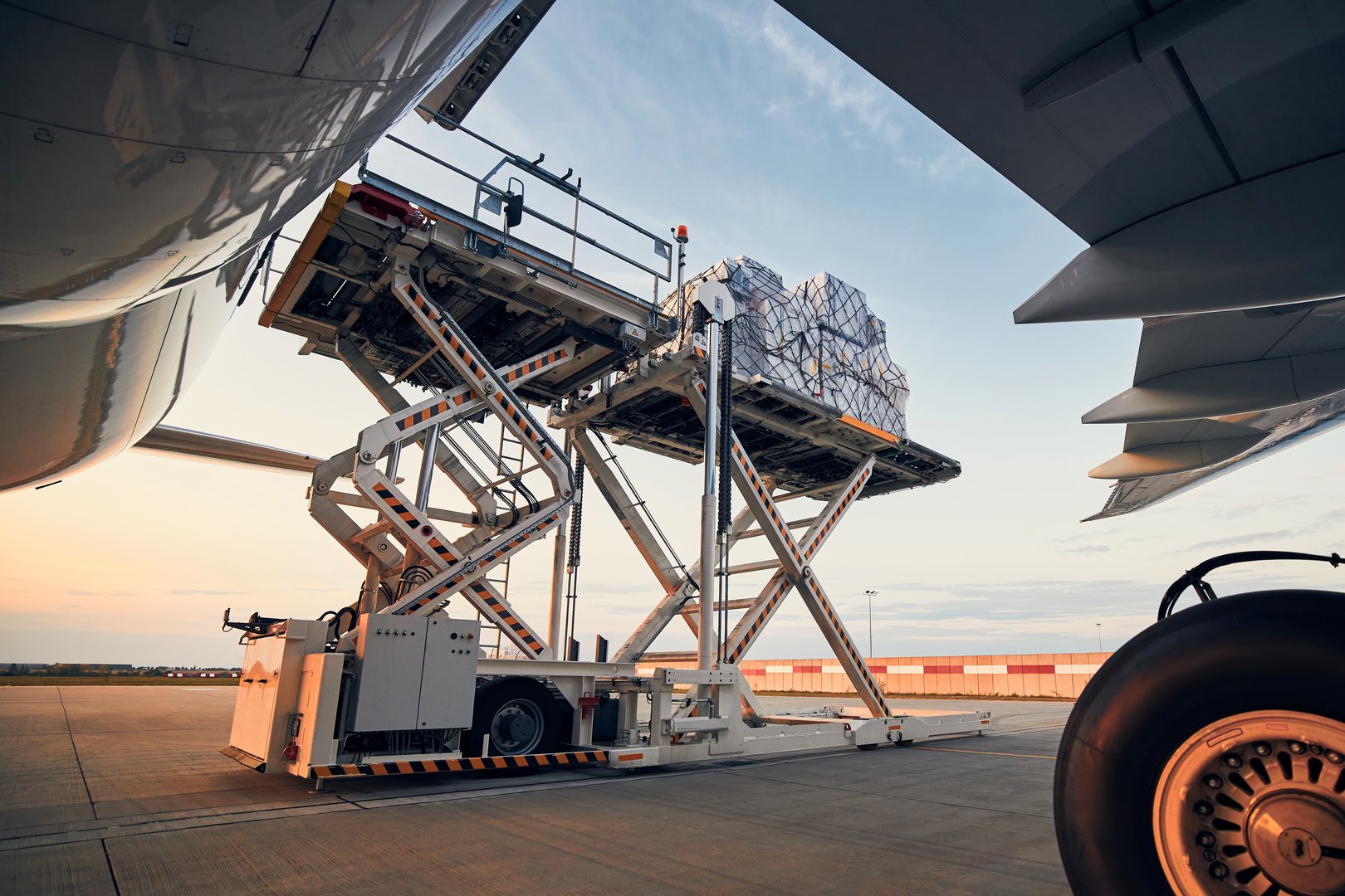 Preparation before flight. Loading of cargo containers to airplane at airport.