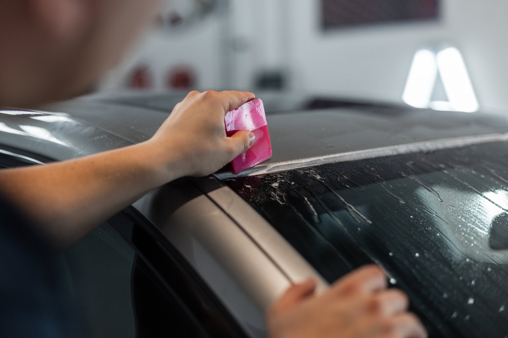 Professional man covers a car with protective film