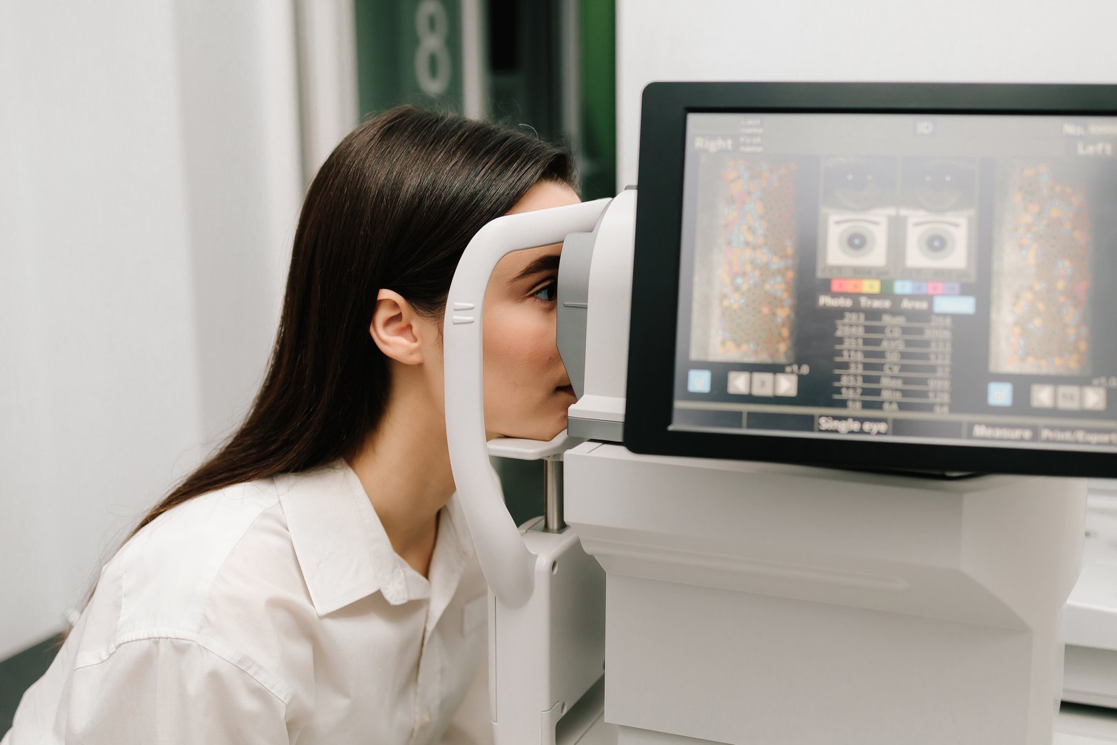 Retinal scans on display, assisting in early diagnosis of eye diseases. Girl undergoes an OCT eye exam using advanced optical coherence tomography equipment