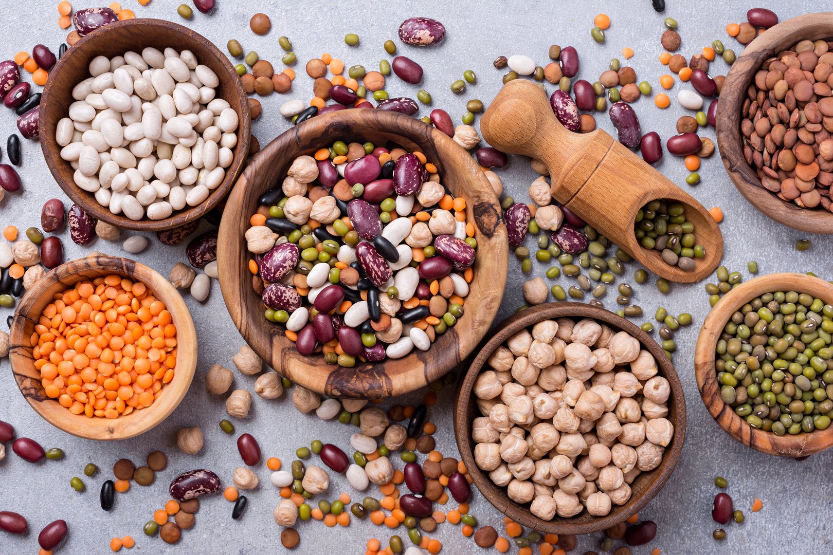 Top view of different beans, lentils, mung, chickpeas in wooden bowls for tasty meals
