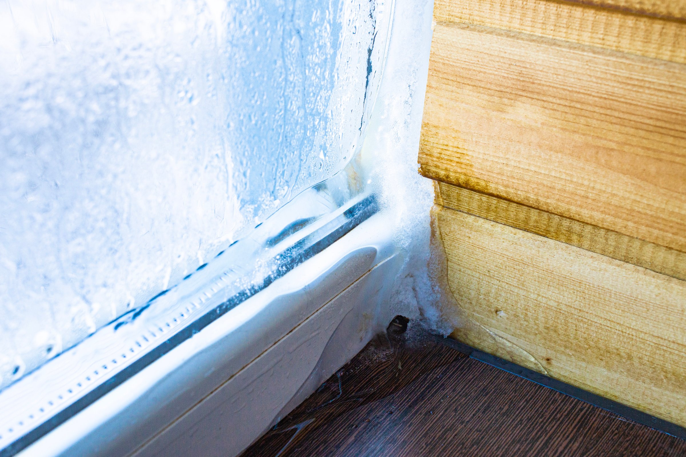 Years on the window glass in the house after condensation of moisture due to the temperature difference outside and inside the room, a defect in construction. High quality photo