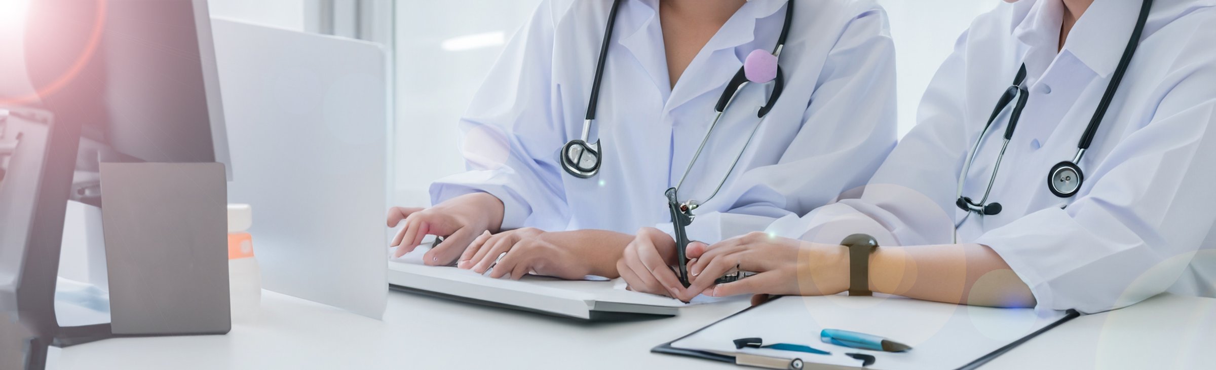 women in medical suits reciting a patient in front of a pc