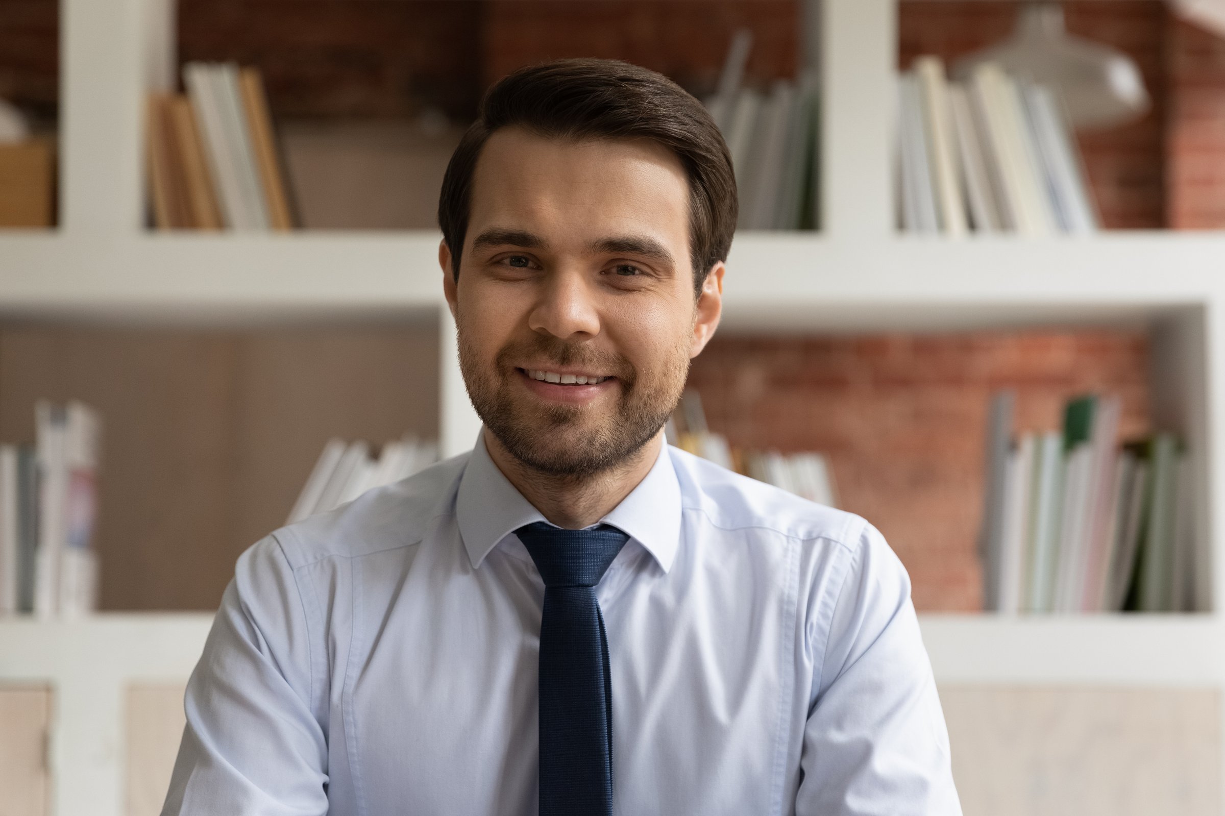 Profile picture of smiling young Caucasian businessman have webcam digital event online with client customer. Headshot portrait of happy male employee speak talk on video call with business partner.