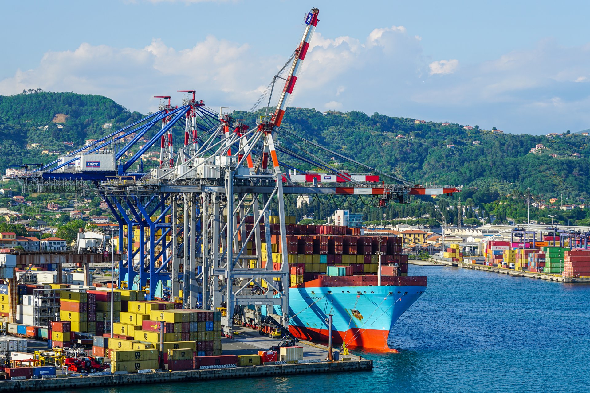 La Spezia, Italy- May 28, 2024: Large, high fully loaded container ship at the port container terminal with many high cranes
