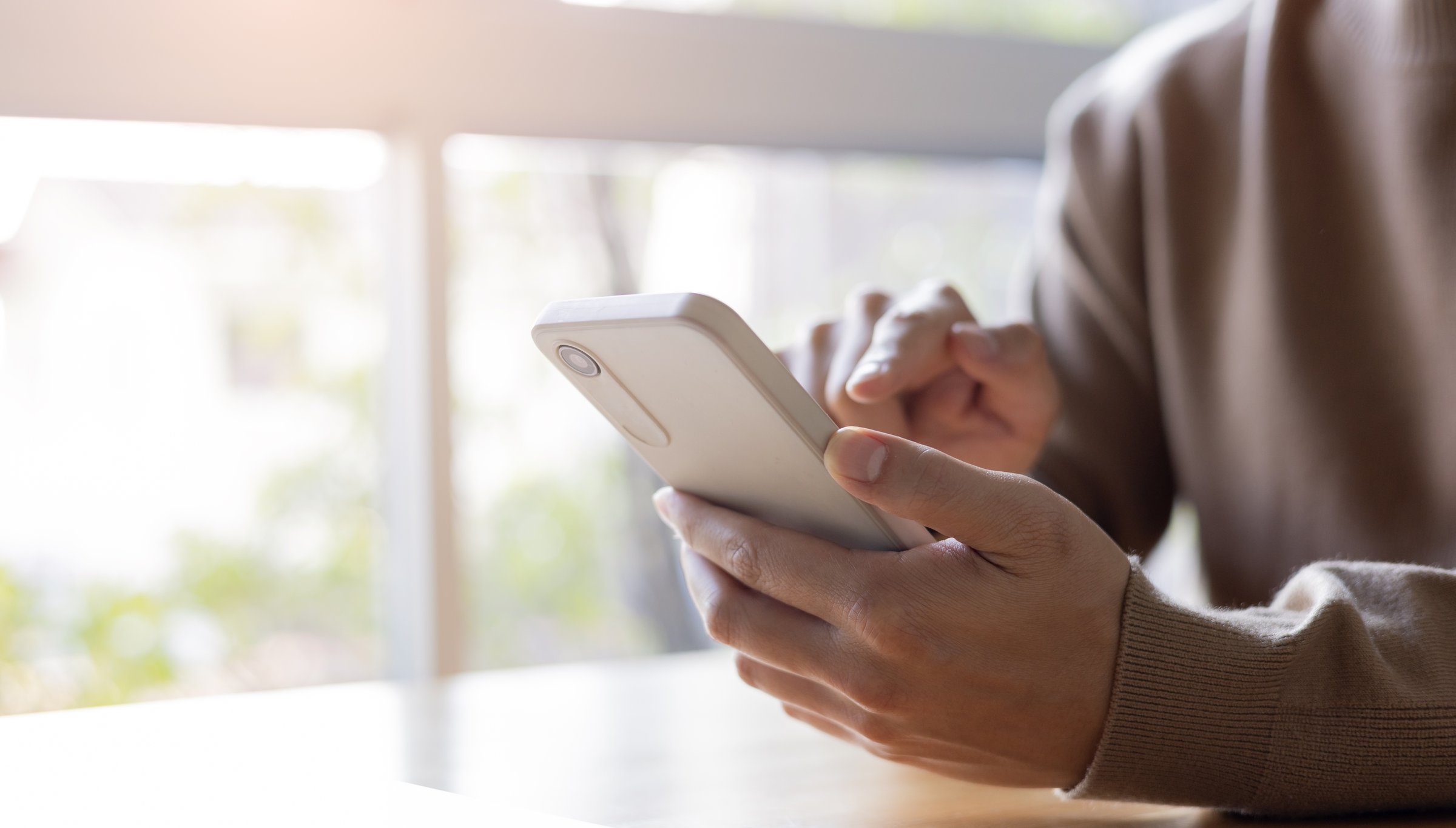 close up young man sit in the living room and hold smartphone and looking on device screen for check notification or read news or alert from application at home for people lifestyle and technology concept