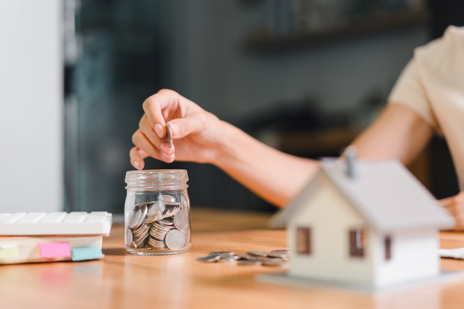 Hand putting coins into jar - SMSF property investment