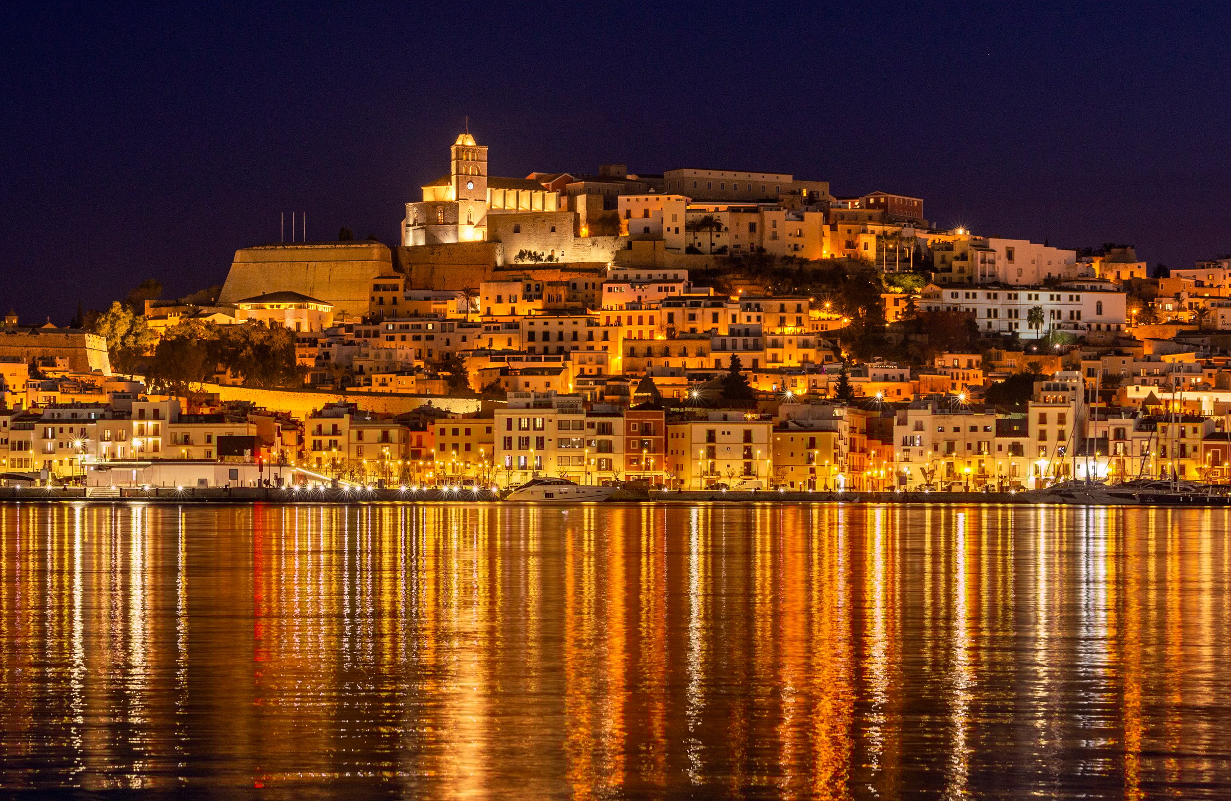 View of Ibiza old town at night with the nightlights reflected on the harbor, Ibiza Island, Balearic Islands, Spain