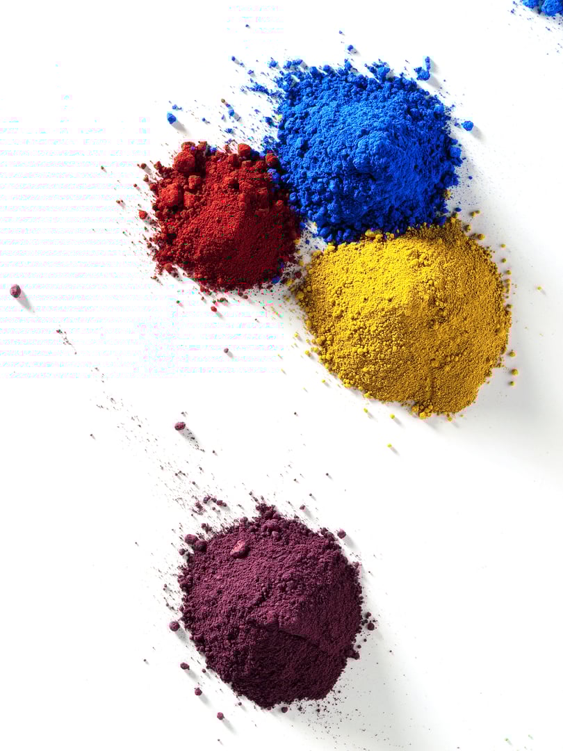 Piles of colored mineral pigments on a white background