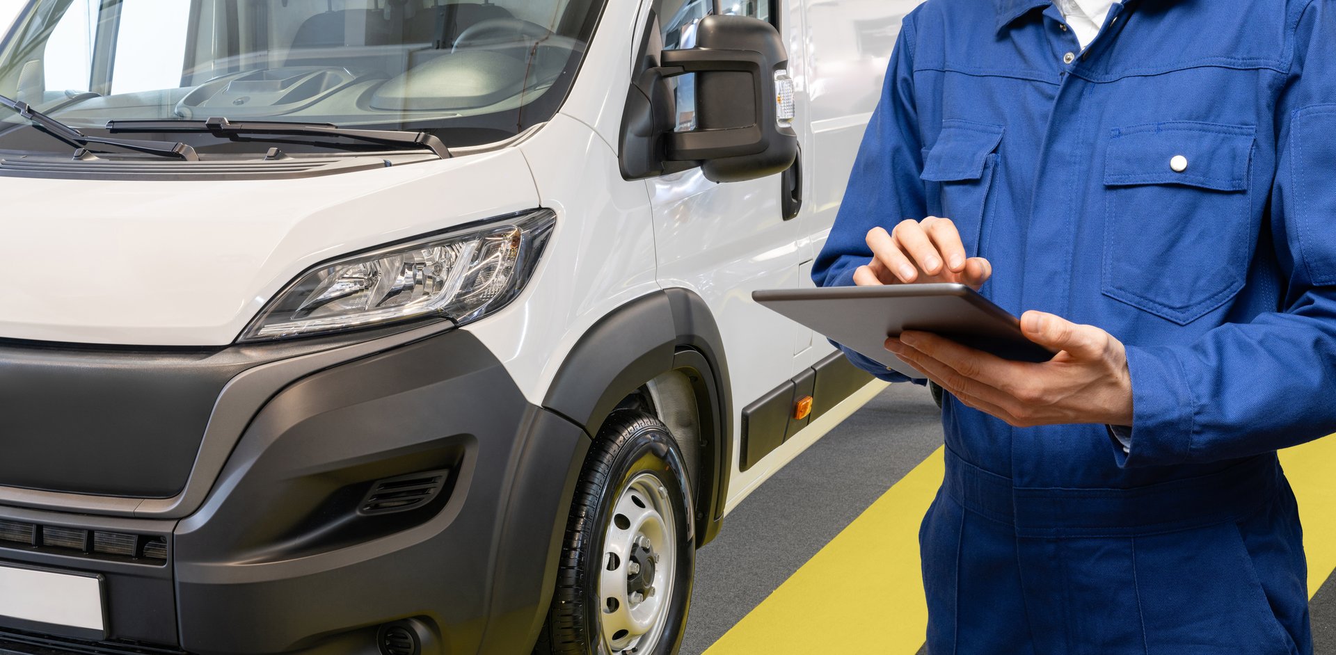 Manager with a digital tablet on the background of delivery van. Fleet management.
