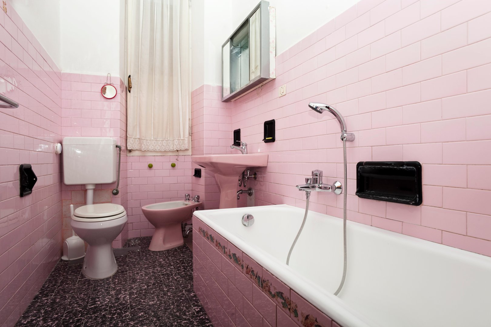 1970s bathroom with outdated tiles pink bathtub