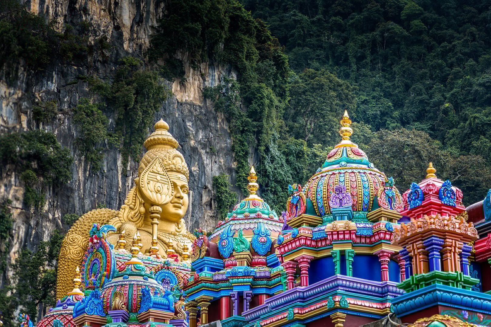 Colorful Saints and a golden Buddha in front of  the Batu Caves, Kuala Lumpur, Malaysia