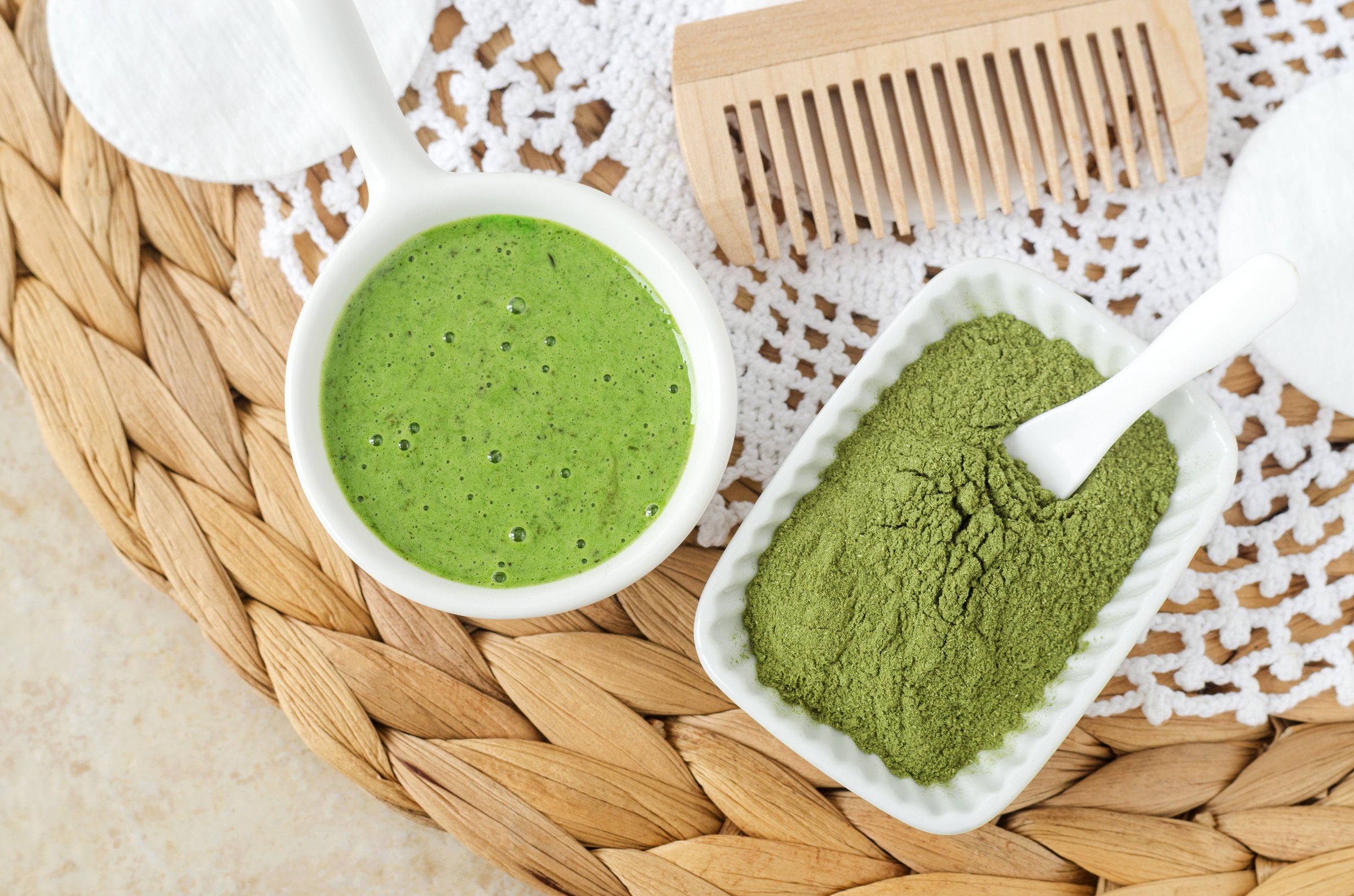 Matcha powder and homemade green tea (kelp, algae, spirulina) face or eye mask (scrub) in a small white bowl. Natural beauty treatment and spa recipe. Top view.